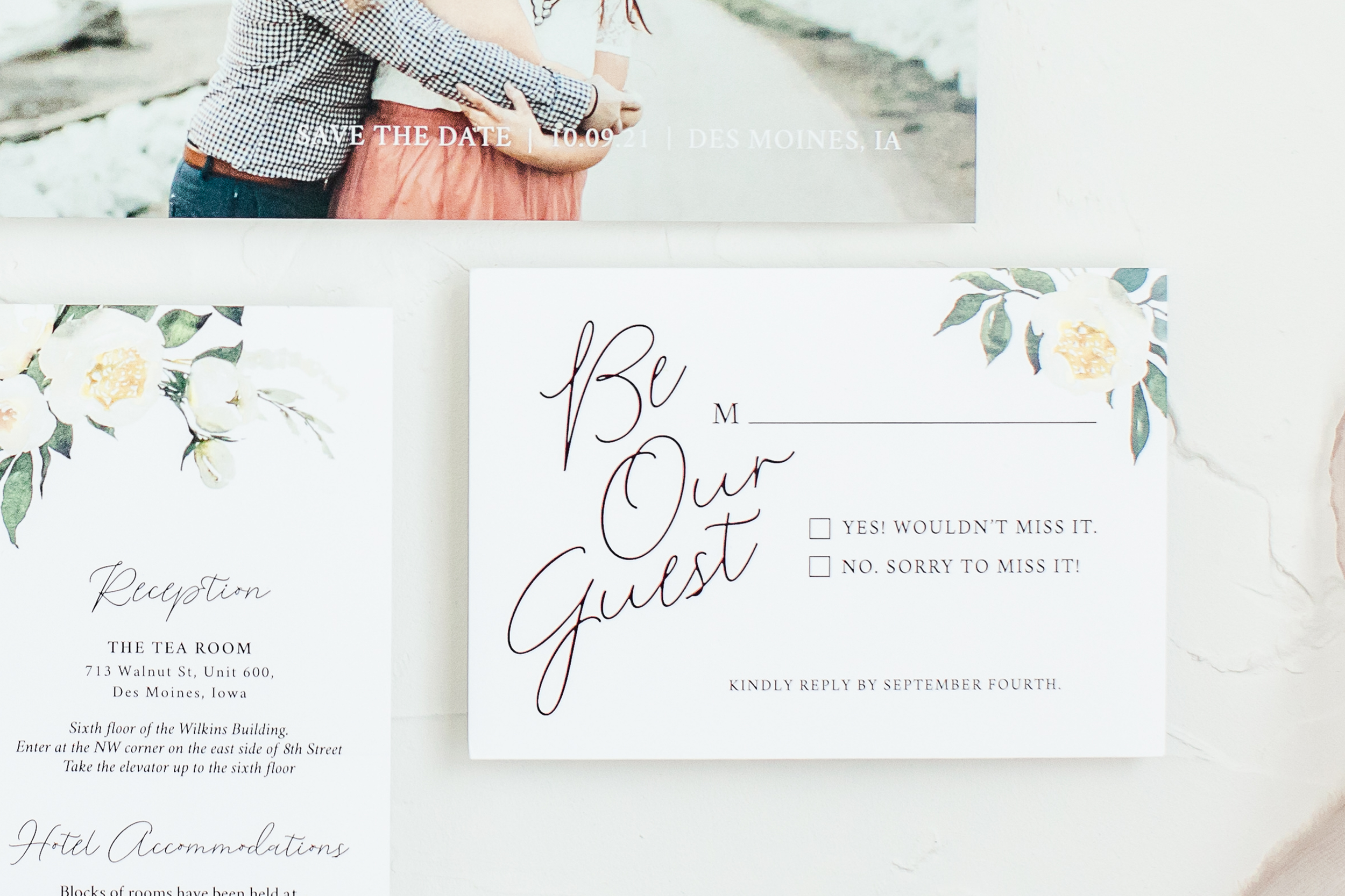 A wedding invitation with floral designs and elegant cursive text, and a part of a second invitation visible showing a reception address.