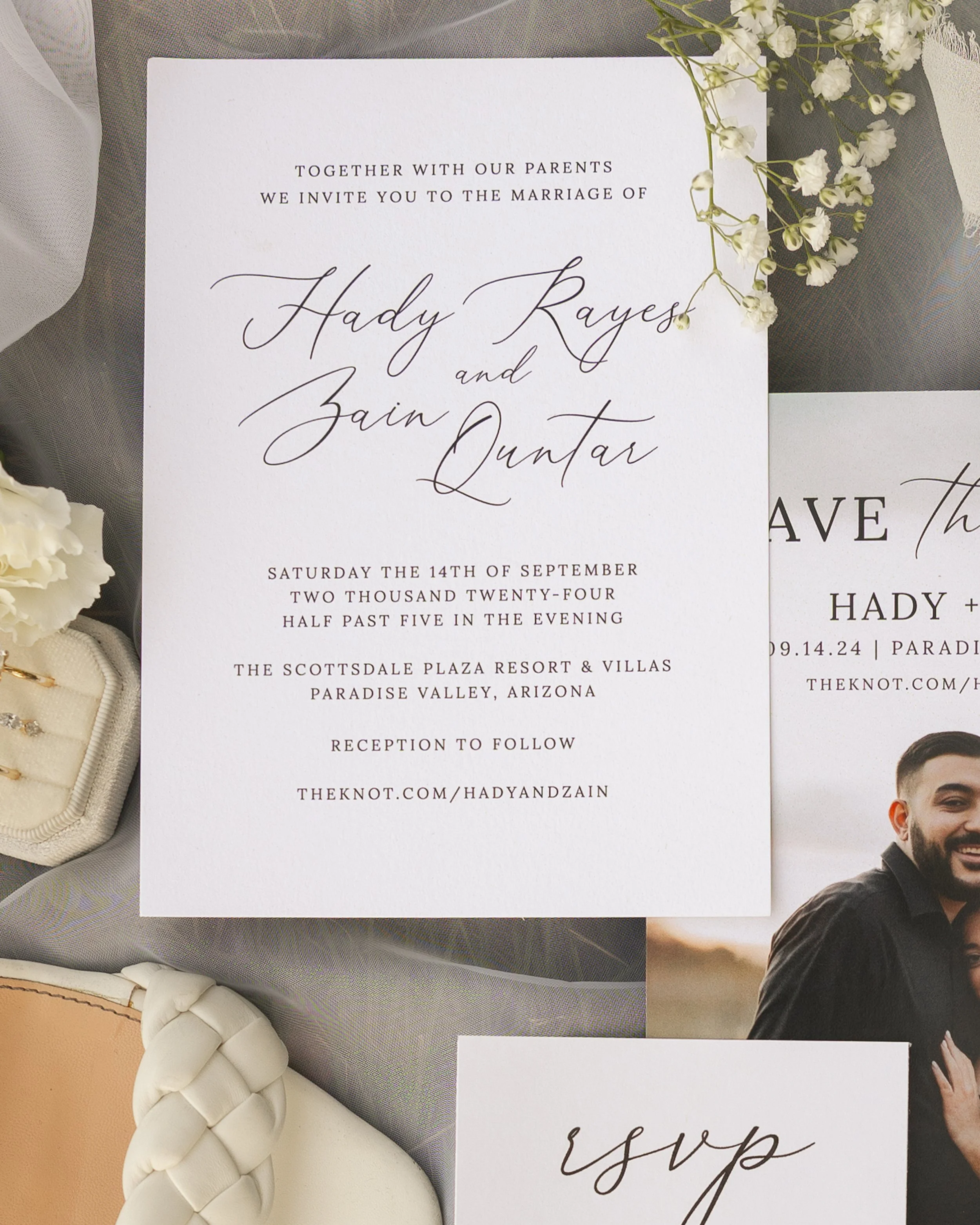 Wedding invitation card with floral decoration on top. The card contains details of the wedding celebration including the names of the couple, Hady Kaysar and Zain Quntar, date, time, venue, and website.