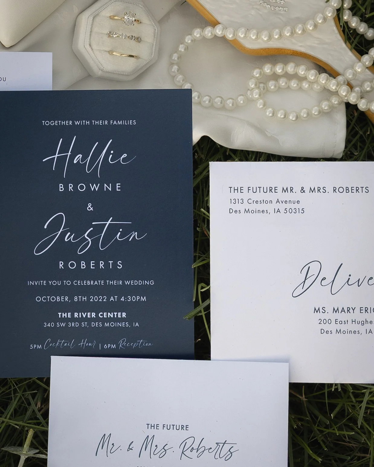 Wedding invitation with a navy blue cover, white text, and a white wedding invitation. The invitation details a wedding celebration for Hallie Browne and Justin Roberts at The River Center in Des Moines, Iowa, on October 8, 2022, at 4:30 PM. The even