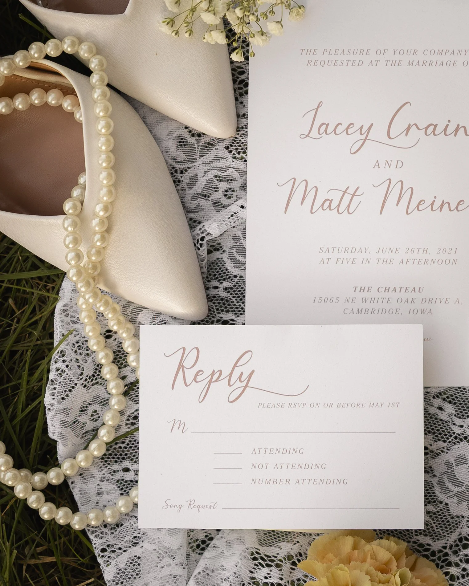Wedding invitation with names Lacey Crain and Matt Meine, date June 26, 2021, location details, and RSVP card, decorated with pearl necklace, lace fabric, white shoes, and flowers.