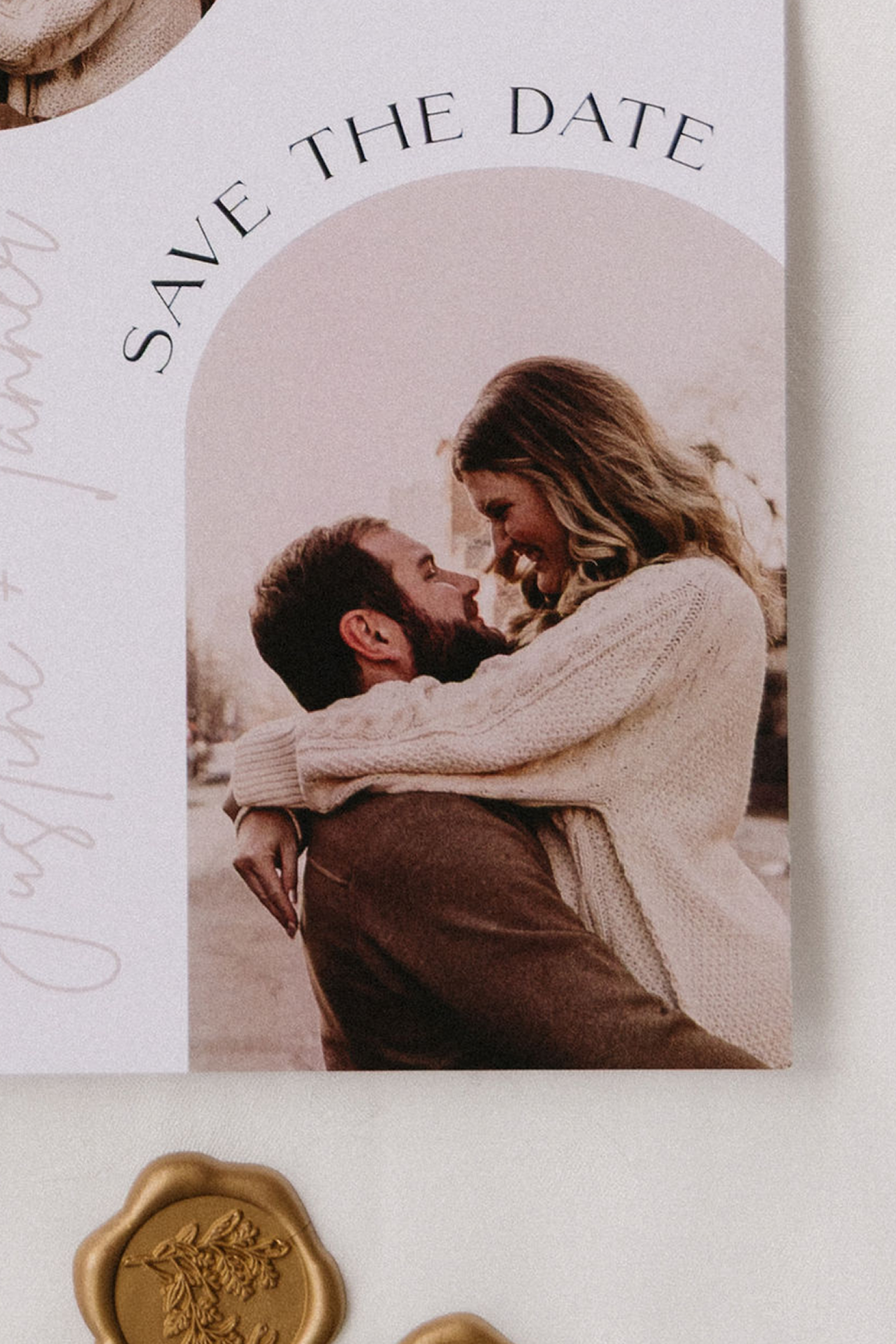 A photograph of a man and woman embracing outdoors, with the woman atop the man, both smiling and looking at each other.