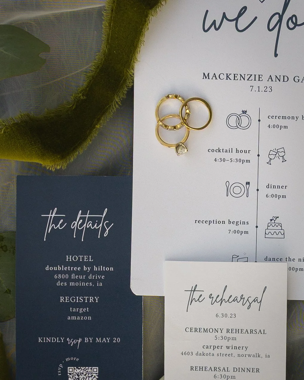 Wedding invitation with gold rings on top, showing the event details for Mackenzie and G, including the date 7.1.23, and schedule of ceremony, cocktail hour, dinner, reception, and dance. Additional details about the hotel, registry, RSVP, and rehear