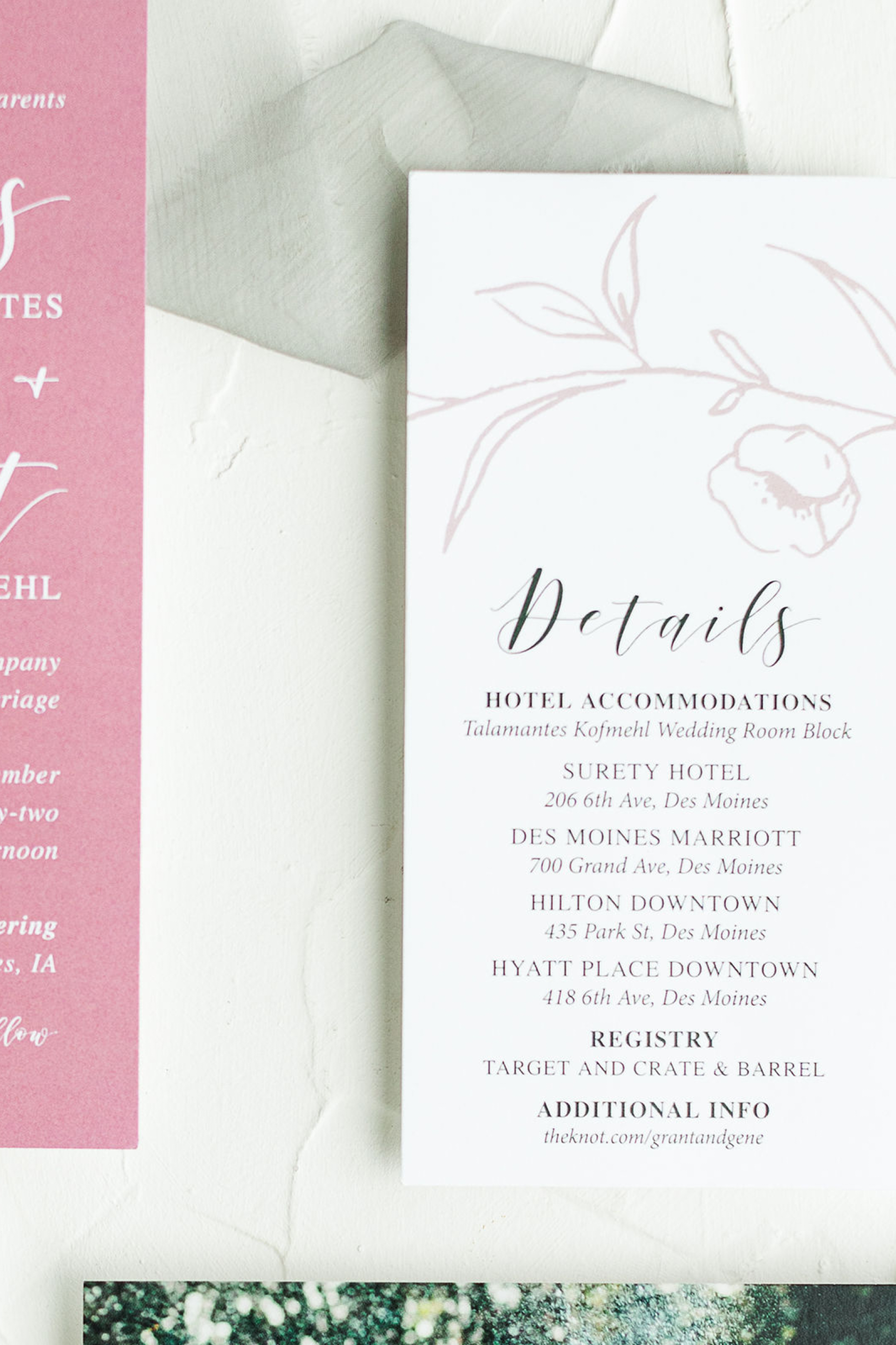 Close-up of a white booklet or menu with a floral illustration and the word 'Details' on the cover, next to a gray envelope and a pink sheet with printed text.