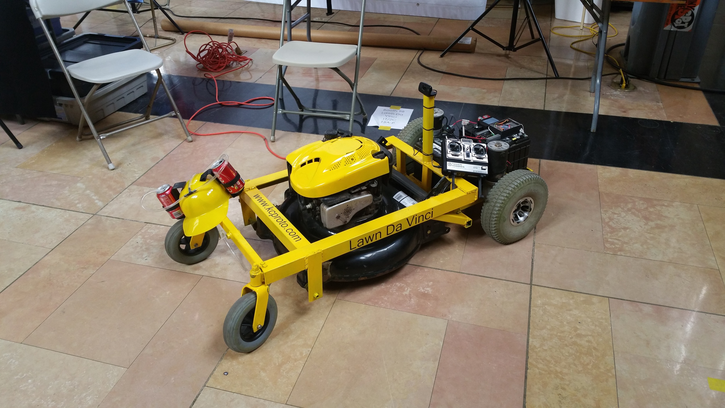 So, you want to make your own remote controlled lawn mower like in the movie "Honey, I shrunk the kids" ? You should. This is a fun project that is very practical and makes mowing the lawn a lot more enjoyable. You will learn a few new skills along the way that will help you be a better maker. First, a disclaimer. Robots are dangerous. Lawn mowers are dangerous. Robot lawn mowers are the danger of mowers times the danger of robots. KC Proto is not responsible for any damage to anything living or inanimate. This project was possible because of the spirit of open source. Pay anything you learn forward. Suggestions on improvements are welcome. I. Gathering materials There are a lot of parts to this project and a few ways to customize it to suite your purposes. These are the supplies I used and they work well. 1. Lots of angle iron and steel- I used 2 inch angle iron and, in retrospect, it was a little bit of an overkill. It is strong enough for me to ride though. 2. Mobility scooter motors- There are a lot of used motors on ebay and they are all pretty similar. If you can get them with the tires on, it will save you a lot of time. 3. Lawn mower - Find a cheap push mower. Any mower should work but make sure it is reliable and it starts. 4. RC remote- I used a Tower Hobbies System 3000 and it works well. 5. Other electronics- There are a few ways to do this but I used an arduino pro mini, a raspberry pi, a Sabertooth 2x25 motor controller, a relay and a webcam. More on this later. 6. 2 Batteries- Pretty much any 12v car or marine battery should work. 2 trickle chargers fill up the batteries in between mowings. 7. Beer hat- Optional, but highly recommended. 