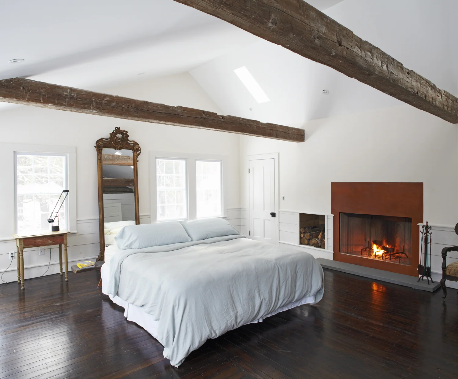 Master bedroom fireplace and antique ceiling beams in the Floating Farmhouse Catskills vacation rental in upstate New York.
