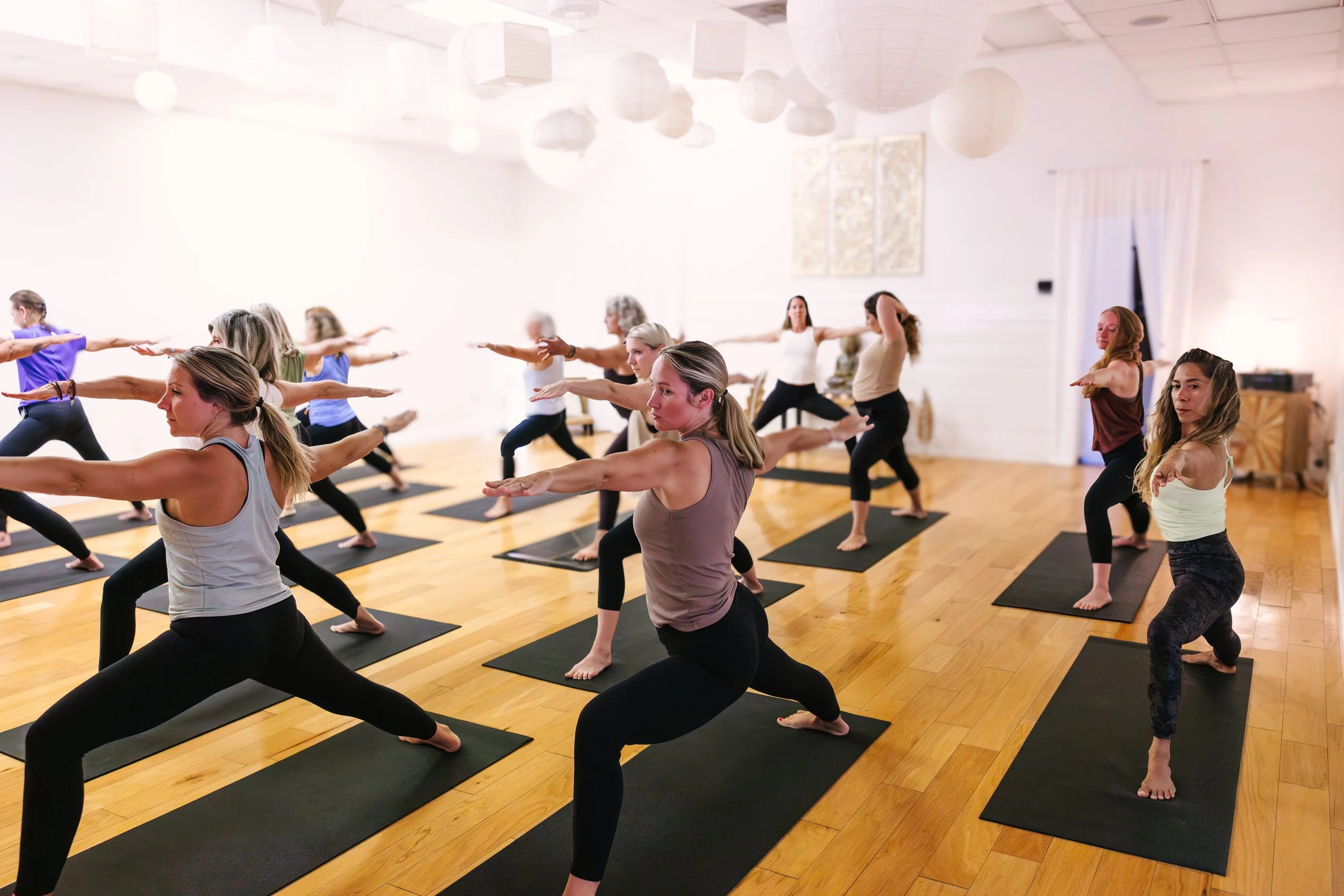 students practicing warrior 2 during an in studio yoga class at Outer Banks Yoga in Kitty Hawk NC