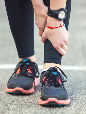 60225870_S_woman_watch_sneakers_shin_splints_hands_grabbing_leg.jpg