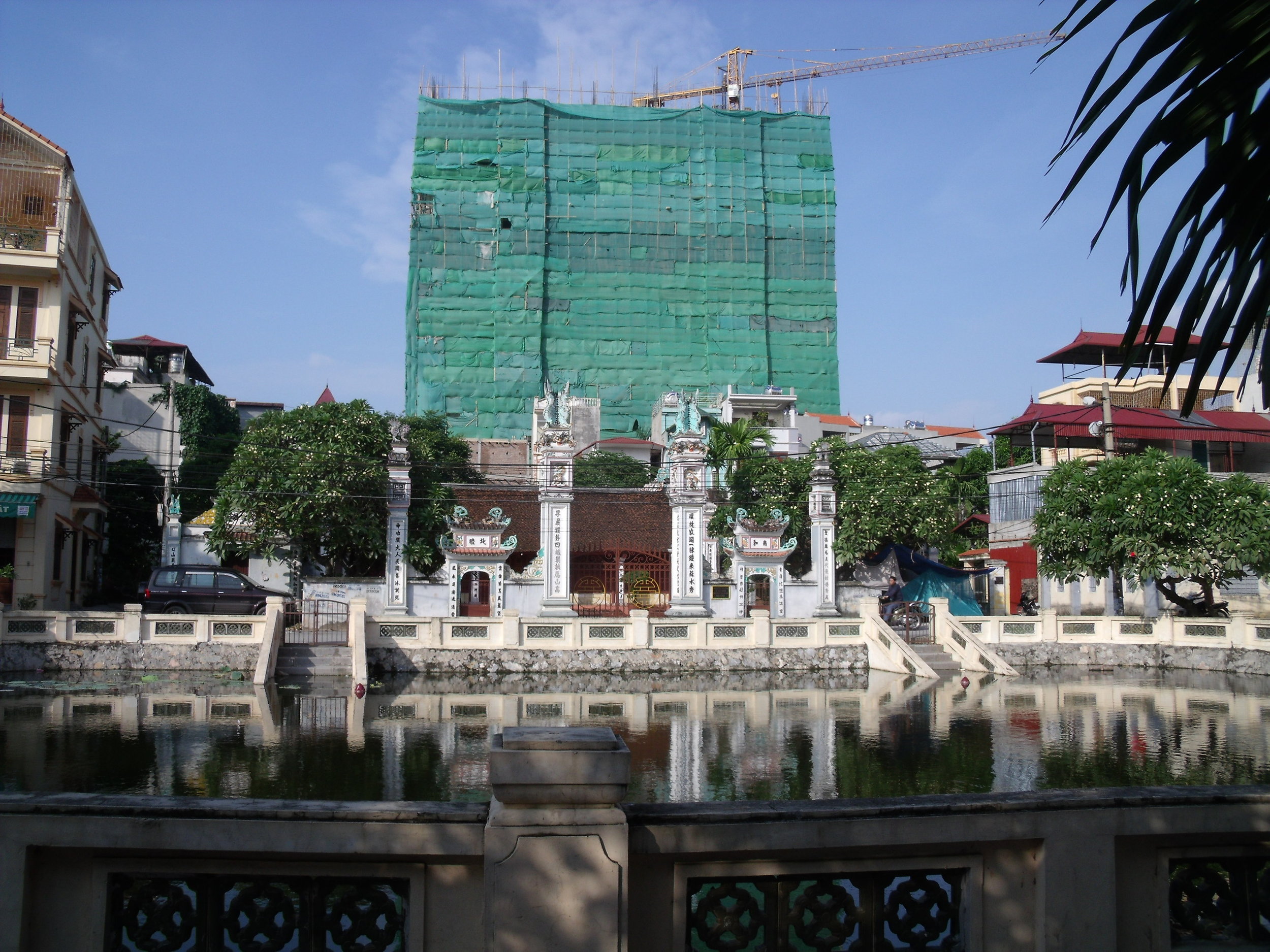 Une nouvelle tour en construction derrière la maison communale d'un des nombreux villages urbains de Hanoï. Crédit: D. Labbé