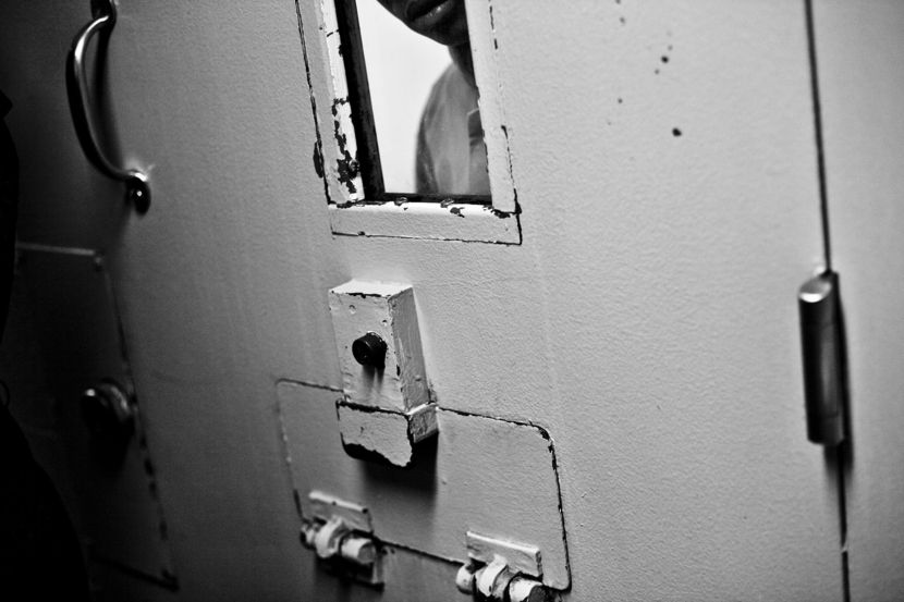 The view looking out of a solitary confinement cell. Guards can close the window at any time. Walls are often covered in feces and urine because inmates act out feelings of frustration and seclusion.