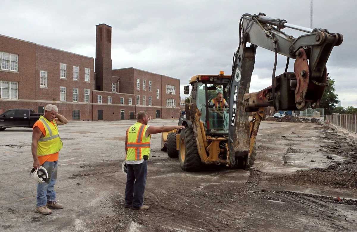 Millstone Weber workers, left to right, Joe Baecht, laborer, James Dixon, superintendent, and Mark Rice, operator begin work on playing surface at Nahed Chapman New American Academy. 