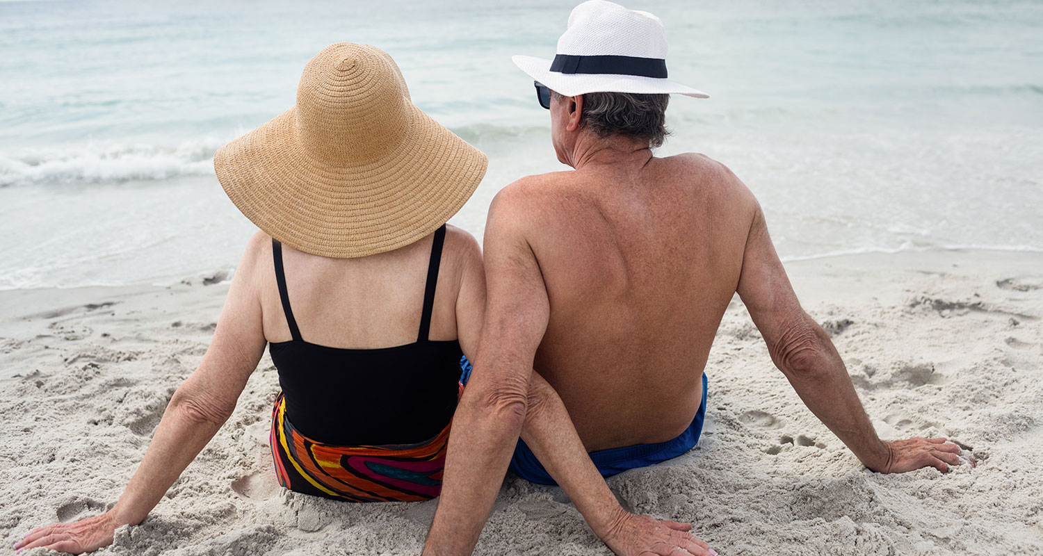 older couple laying on beach photo