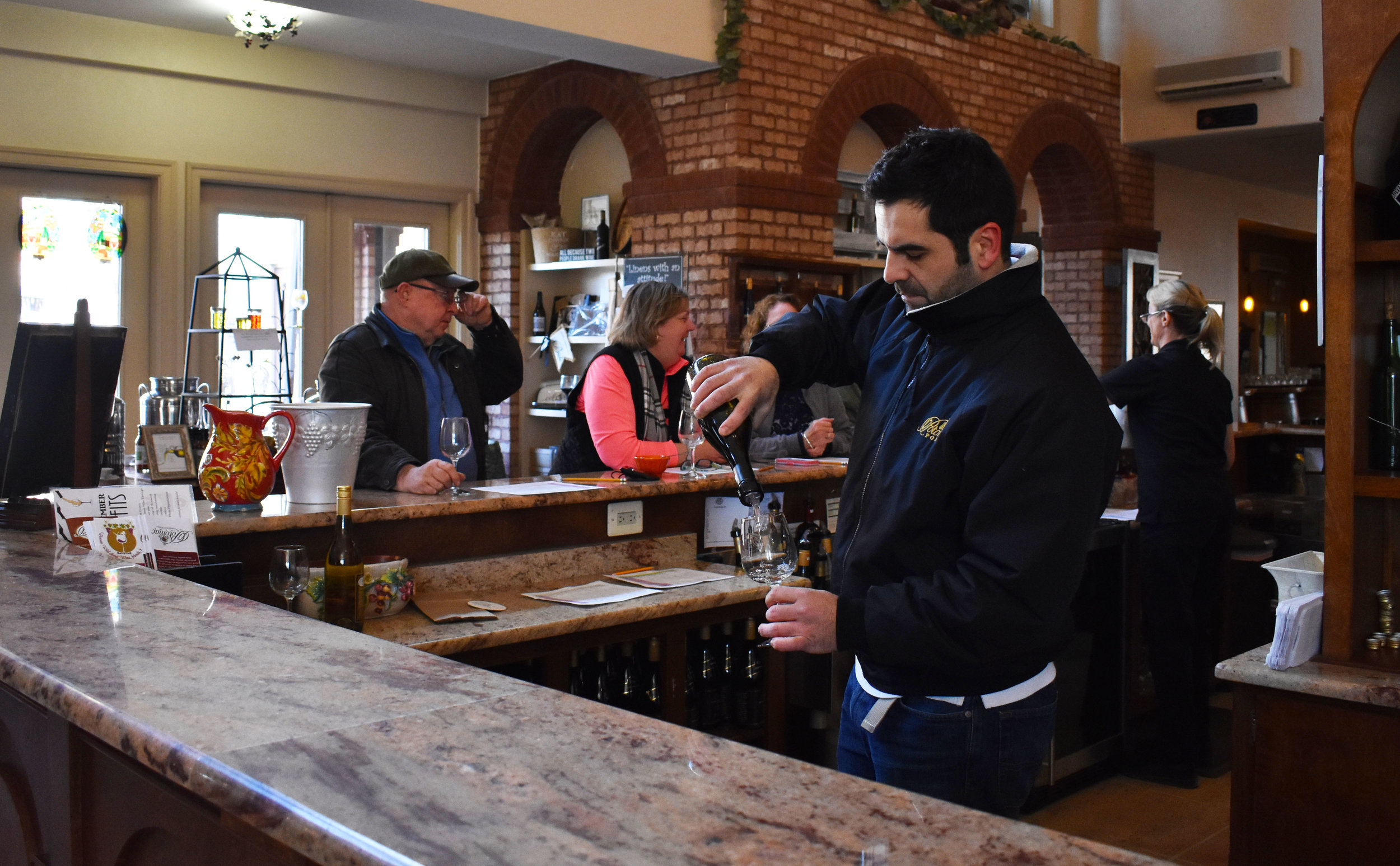 Head winemaker David Pagan Castaño pours a bottle of white wine in the tasting room at Potomac Point Vineyard and Winery in Stafford, Va., Friday, Feb. 2, 2018. (Lindsey Leake/American University)