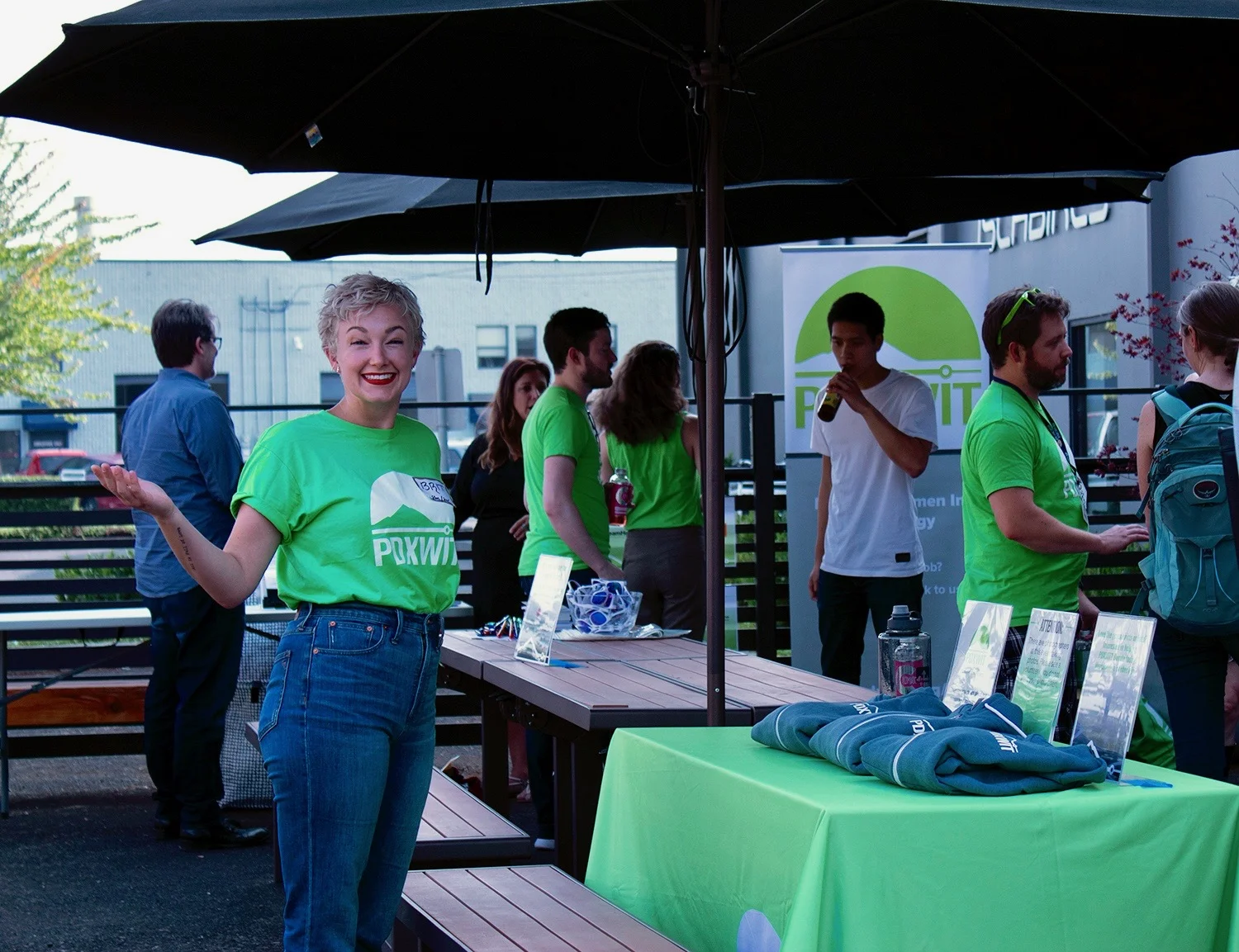 PDXWIT Happy Hour @ Marmoset, 8/21/18, A PDXWIT volunteer greets attendees at a booth