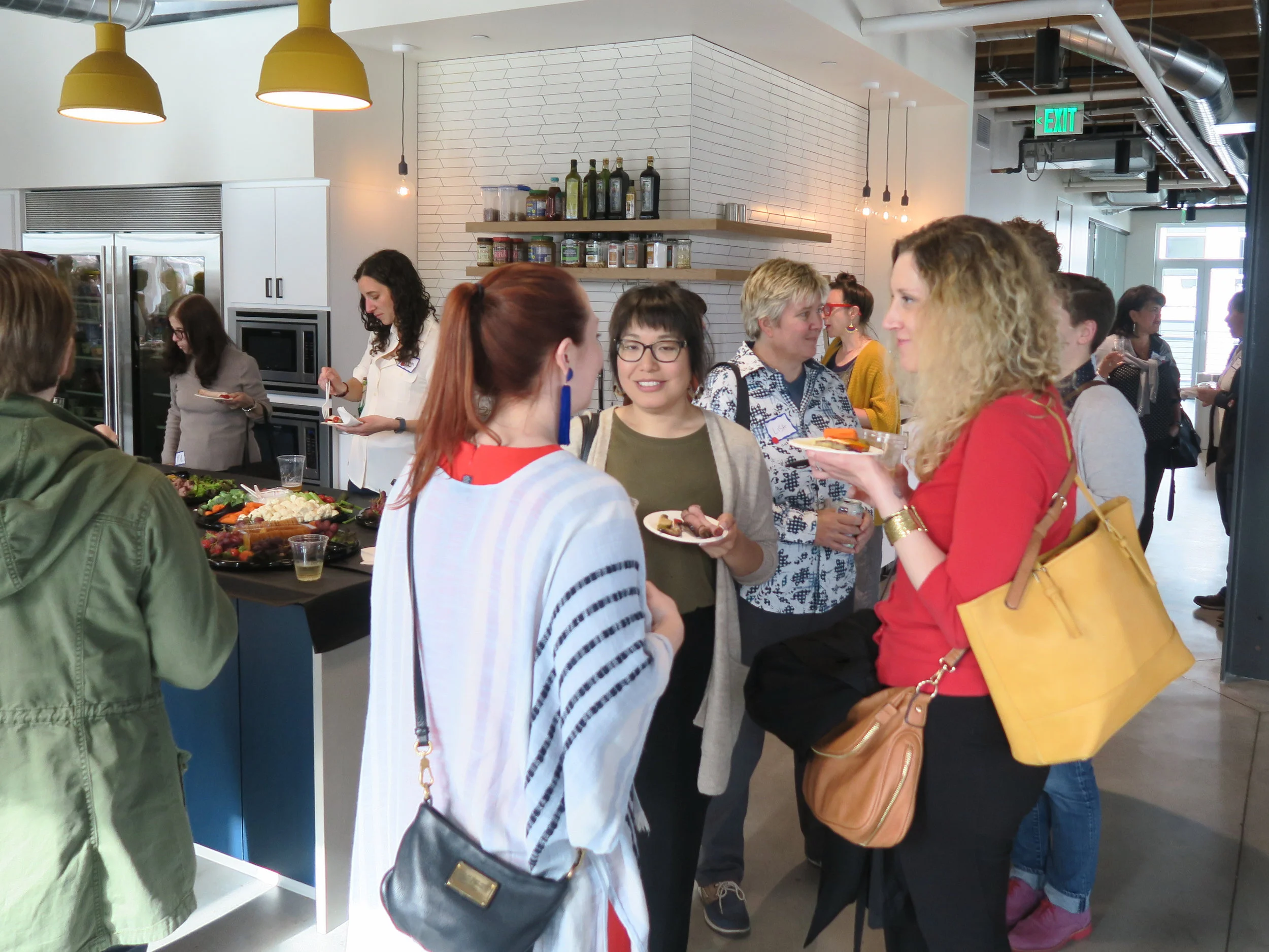 PDXWIT-May-Happy-Hour-Vacasa_2019-05-21_talking-while-getting-food.jpg