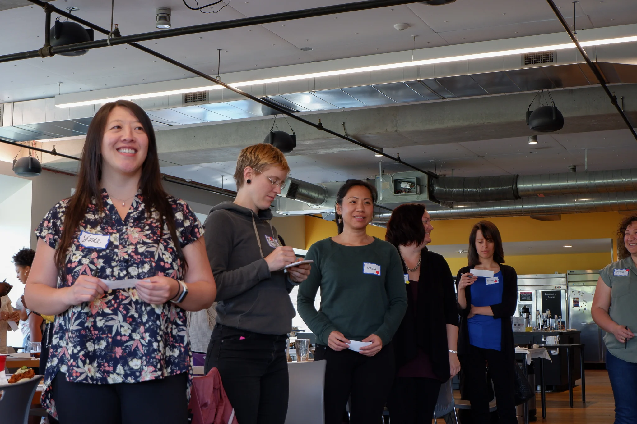 Women standing and smiling, looking at speaker .jpg