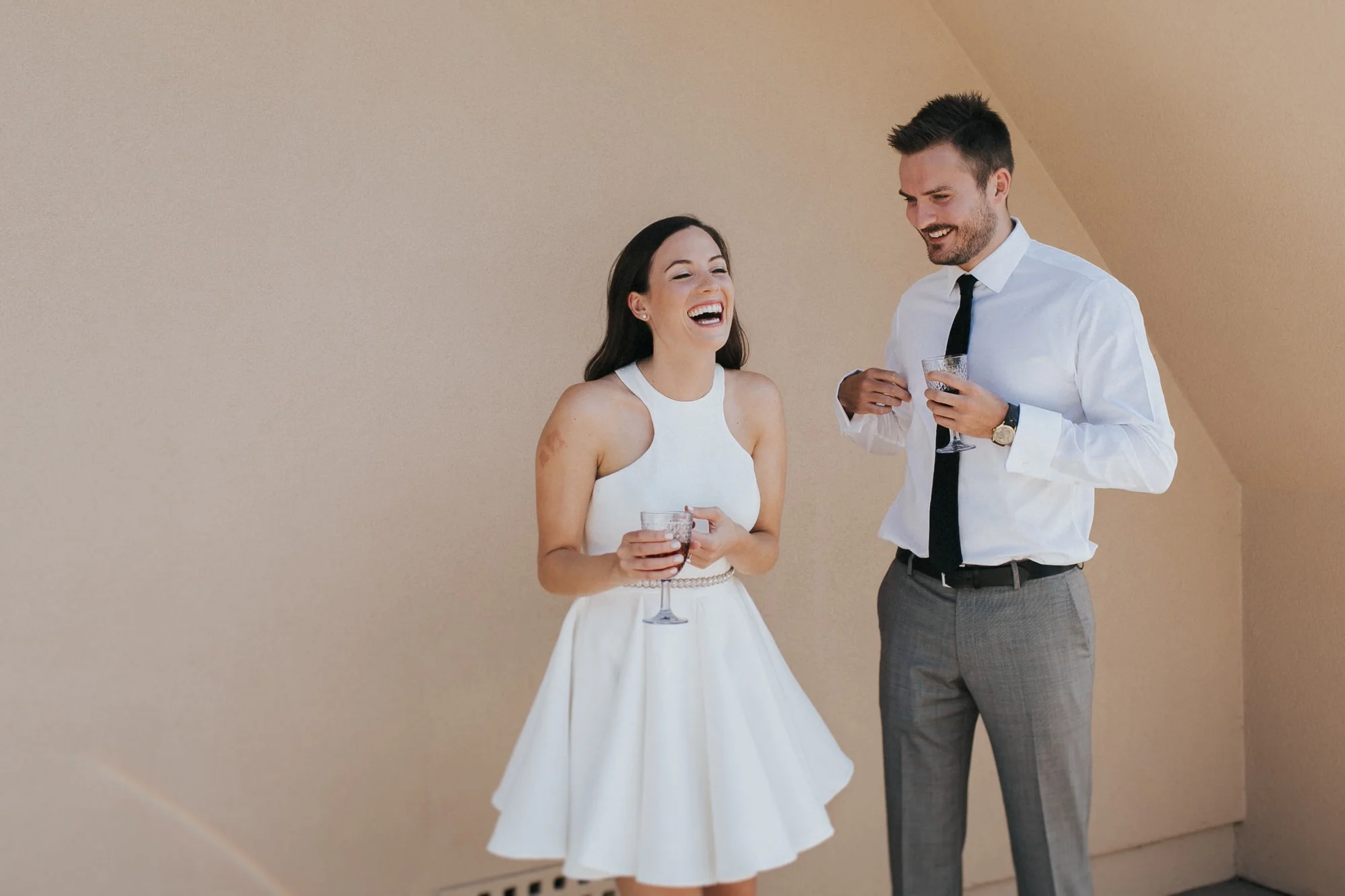 A young couple laughs and enjoys a glass of wine outdoors in this photography session by Lauren Guiffré, a Boise Idaho couples photographer.