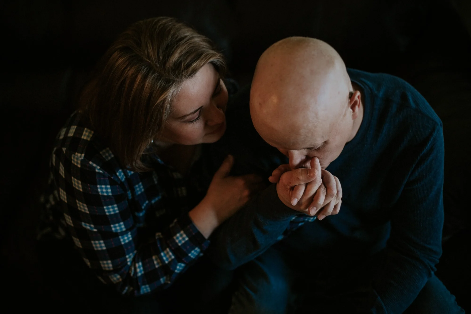A beautiful moment for a couple captured in a photograph as he holds and kisses her hand. Photo credit: Lauren Guiffre Photography
