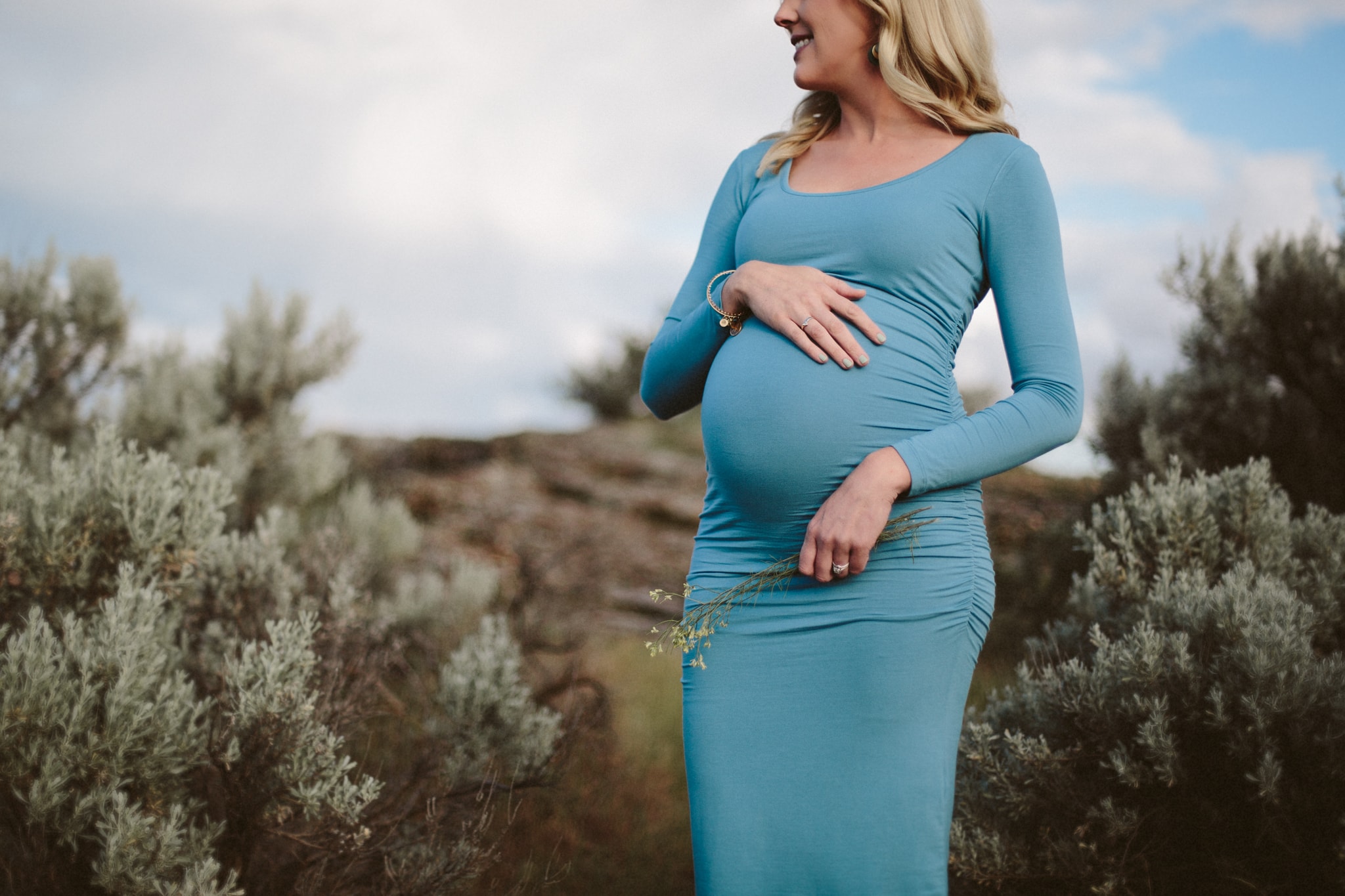 Beautiful mother-to-be wearing a teal dress, during a maternity session by Lauren Guiffre, a Boise Idaho maternity photographer