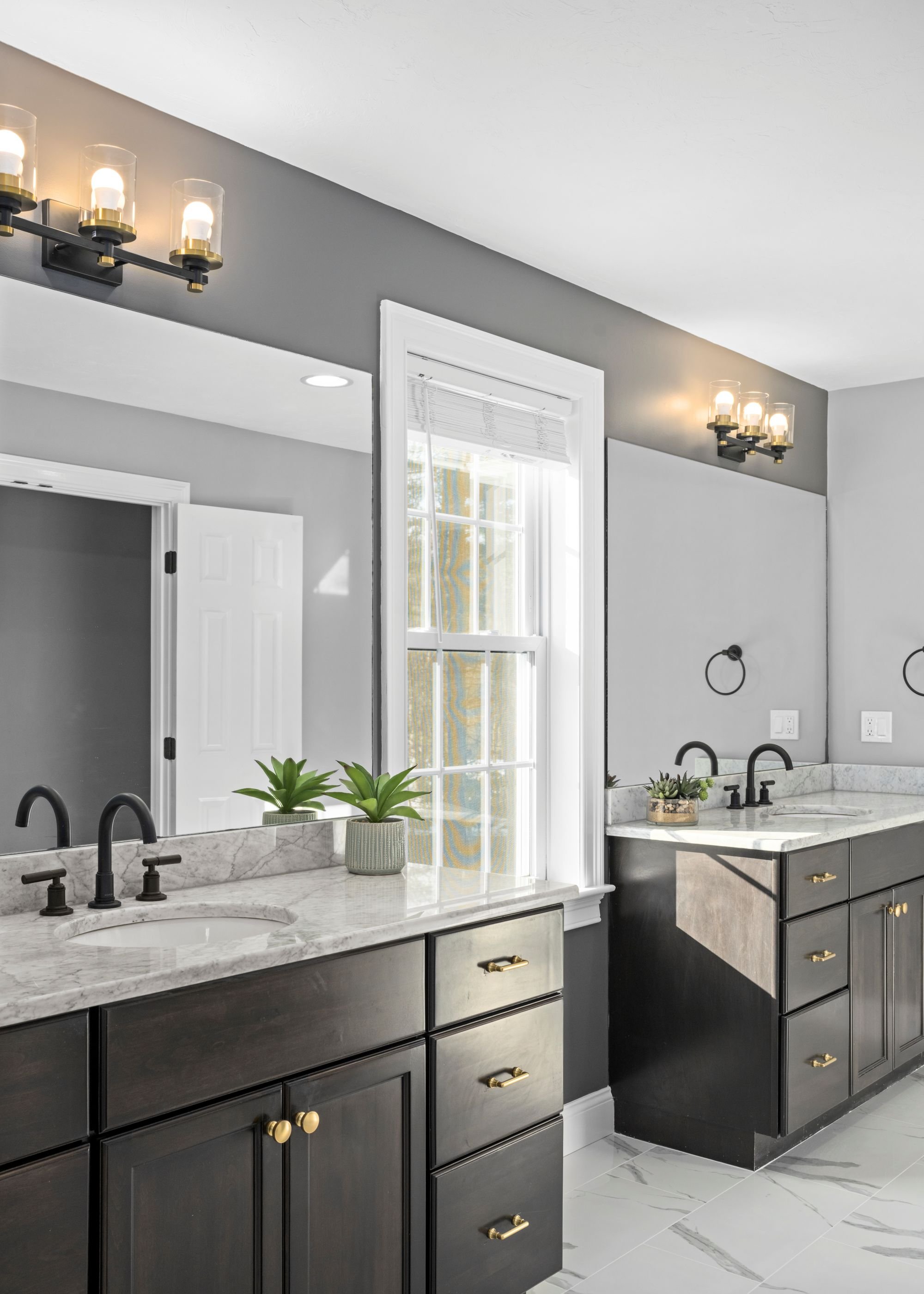 Double vanity with quartz countertops, matte black faucets, and natural window light in a Boxborough MA master bathroom remodel