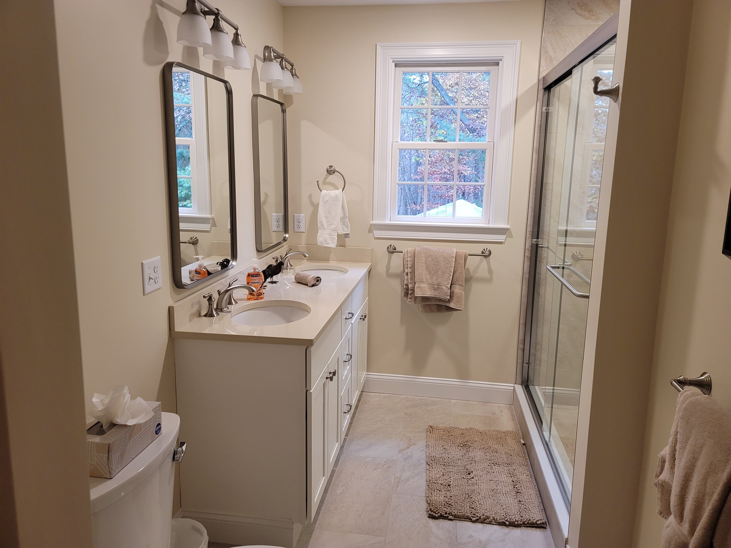 Family bathroom vanity remodel in Stow MA with quartz countertop, Kohler sink, and glass shower enclosure