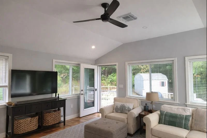 Family room addition interior with vaulted ceiling, ceiling fan, and deck access