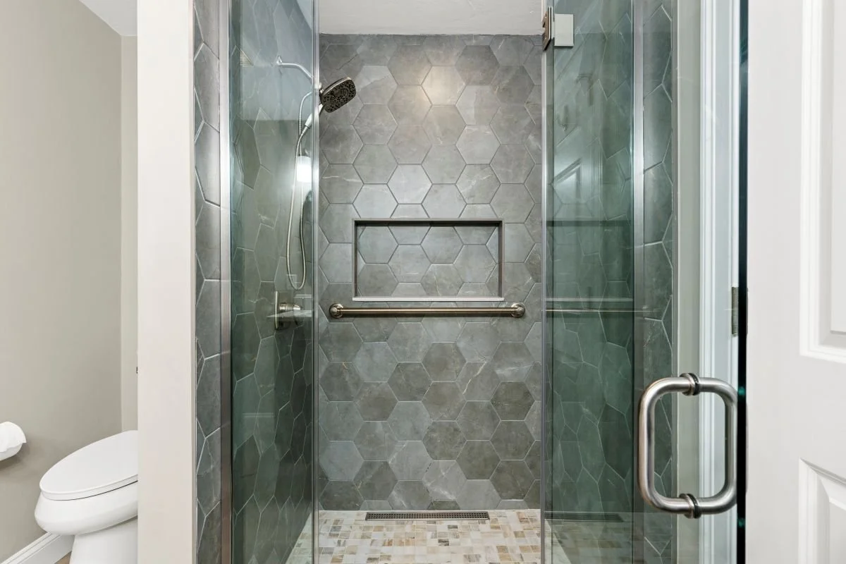 Custom zero-entry walk-in shower with frameless glass door, luxury aging-in-place bathroom remodel Holden MA