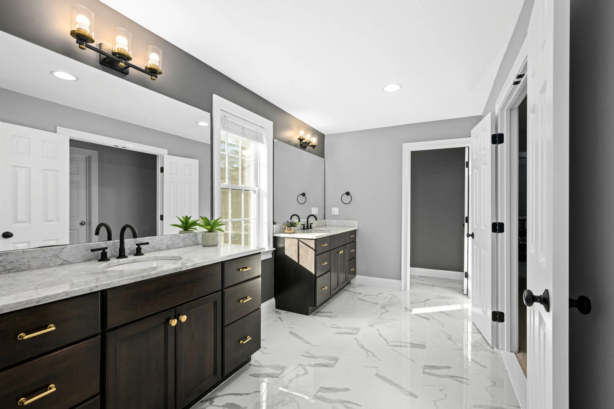 Double vanity with quartz countertops, matte black faucets, and natural window light in a Boxborough MA master bathroom remodel