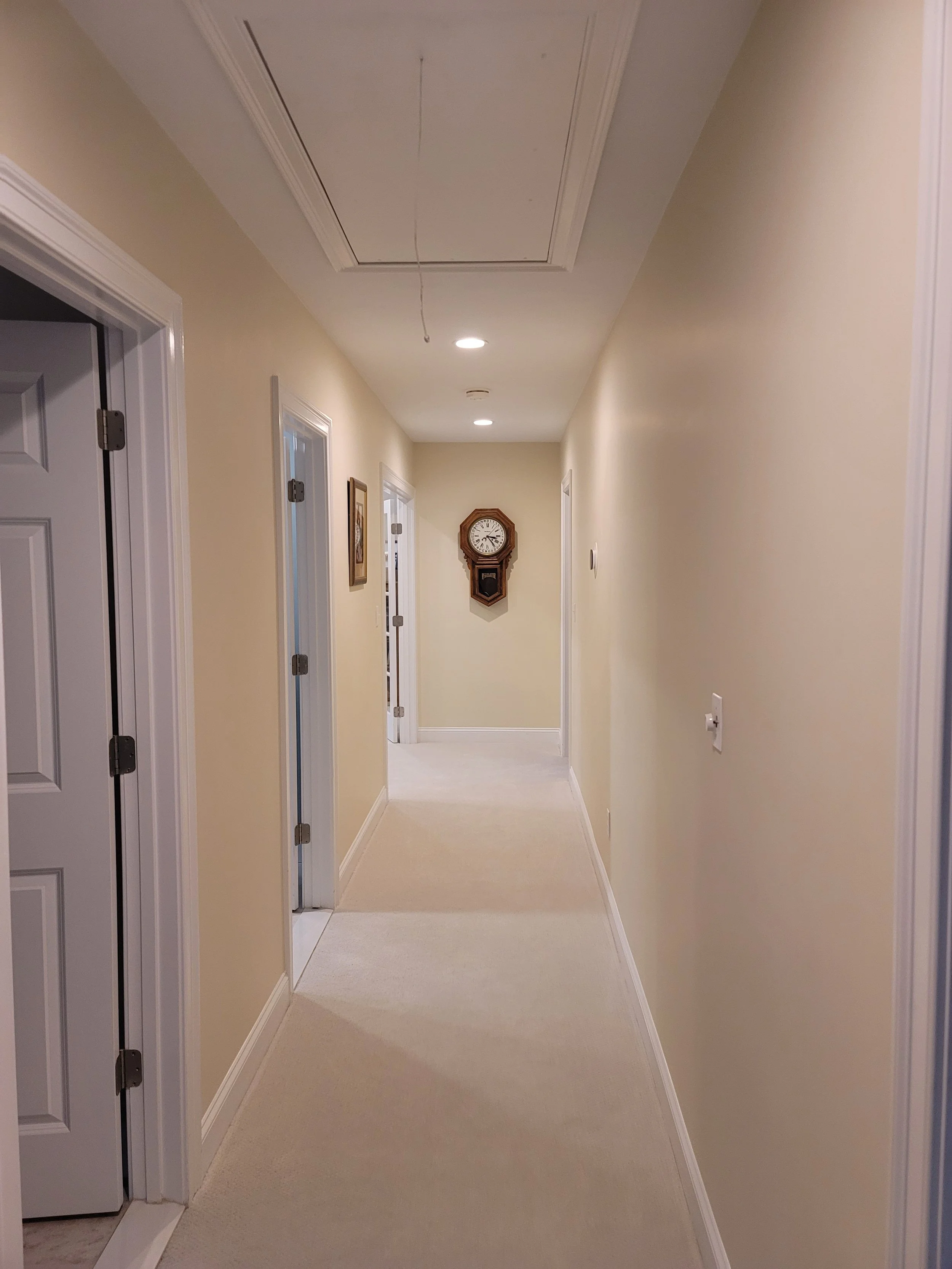 Remodeled hallway in Stow MA with new carpet, recessed lighting, and updated trim