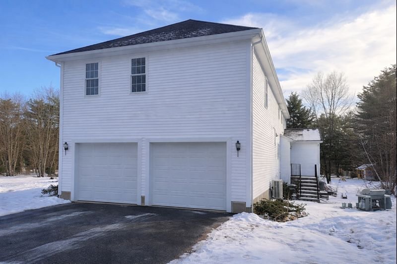 Completed home addition in Hopkinton, MA featuring matching vinyl siding, new roofing, and double-hung windows