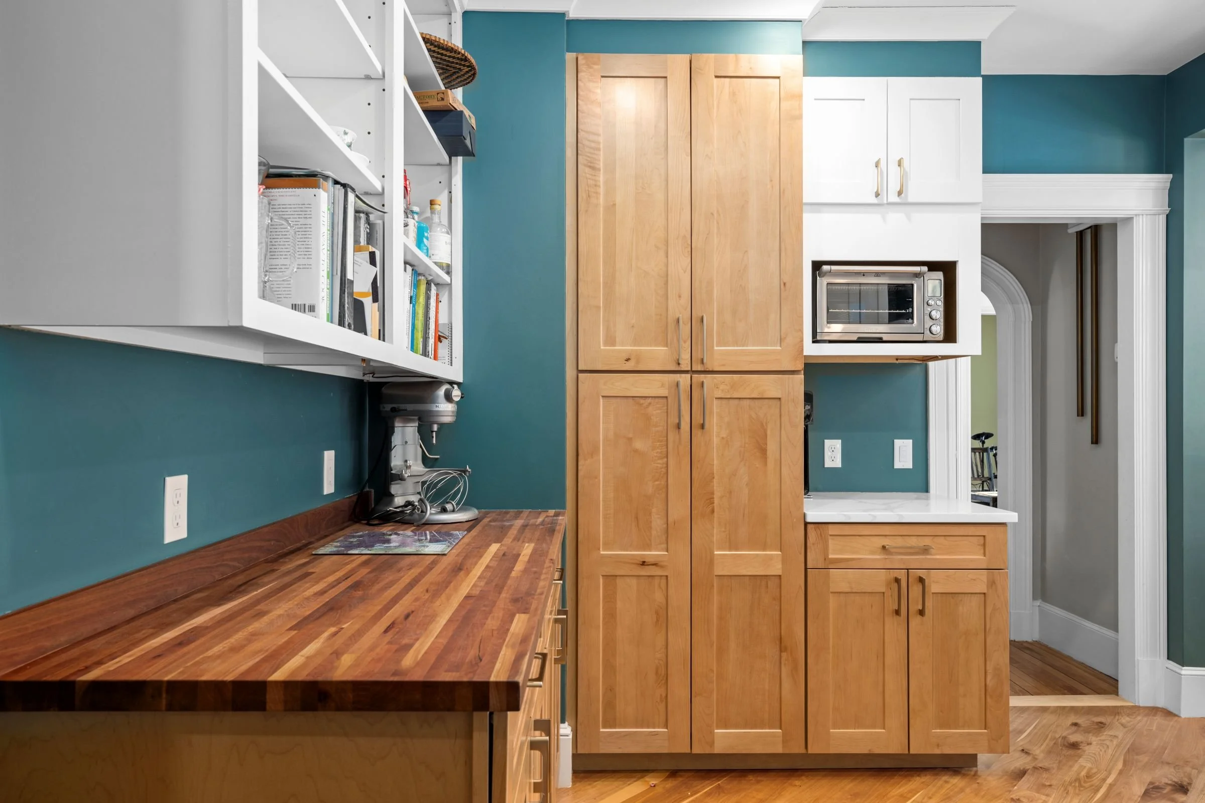 Pantry wall with tall maple cabinetry, butcher block countertop, open shelving, and a built-in microwave in a Worcester, MA kitchen remodel.