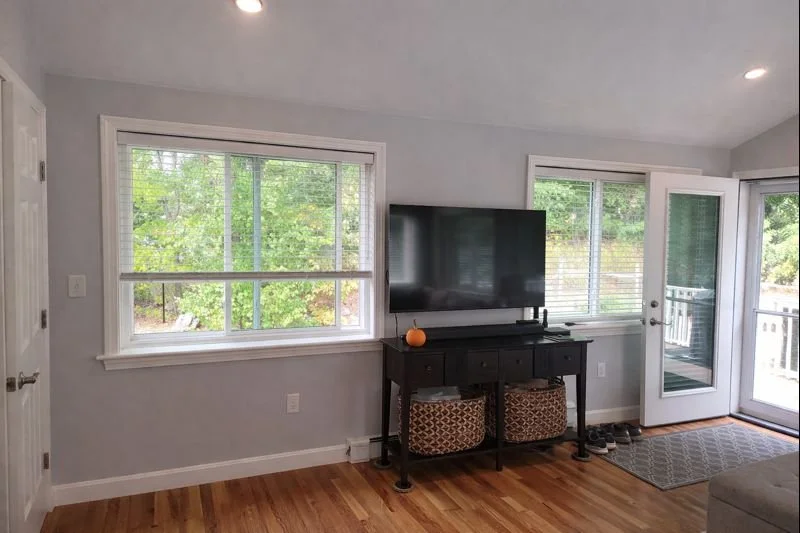 Family room addition interior with hardwood flooring and large windows