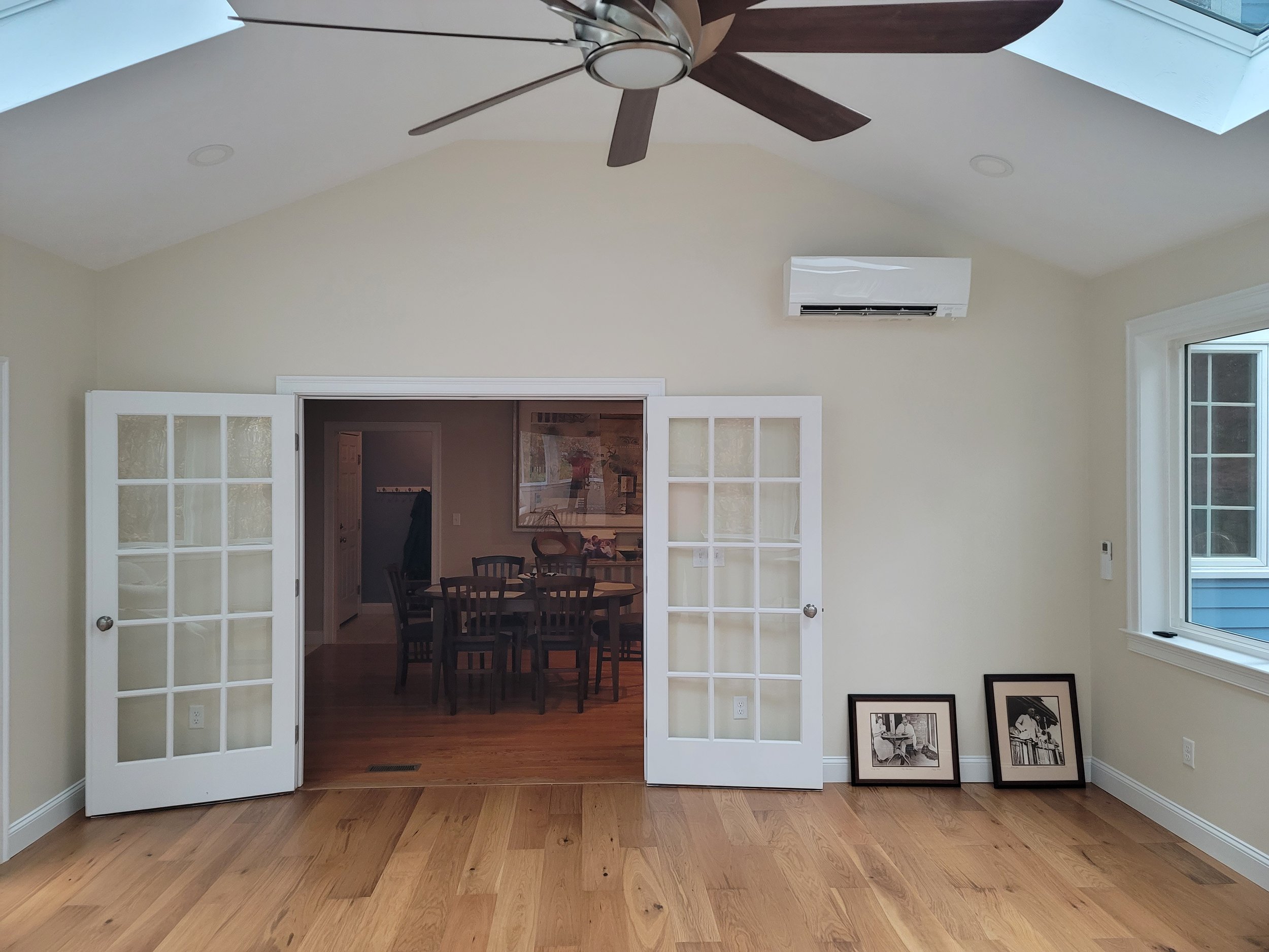 4-season room interior in Stow MA with French doors, vaulted ceiling, and Aura Gold luxury vinyl plank flooring