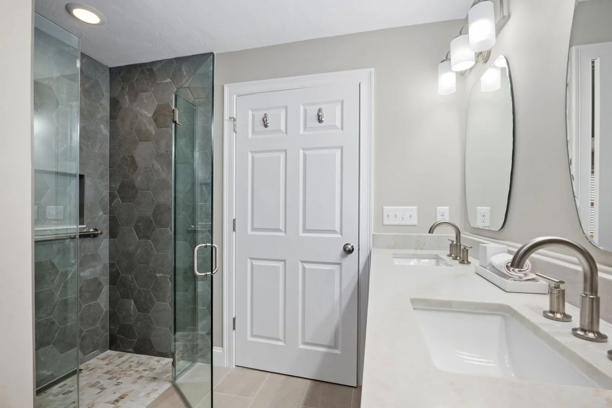 Custom zero-entry walk-in shower with Pulpis Dark Grey hex tile and frameless glass door, luxury aging-in-place bathroom remodel Holden MA