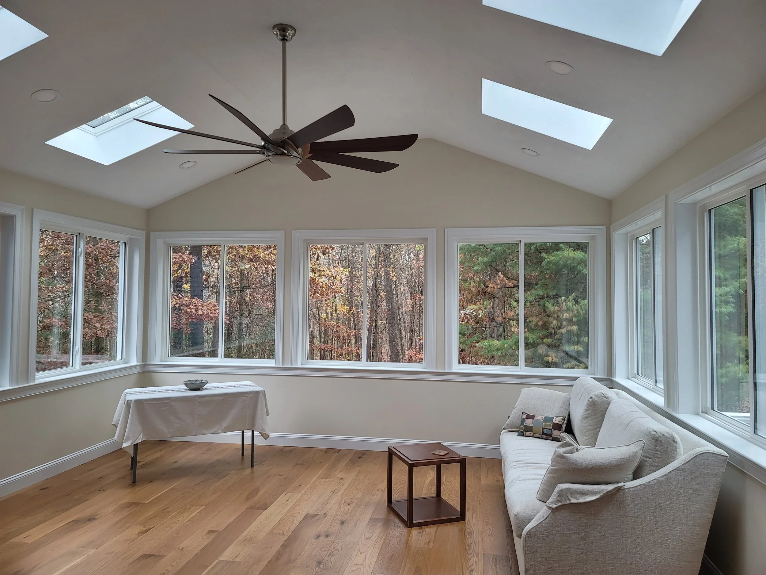 4-season room addition in Stow MA with ProVia windows, Aura Gold luxury vinyl plank flooring, and wooded views