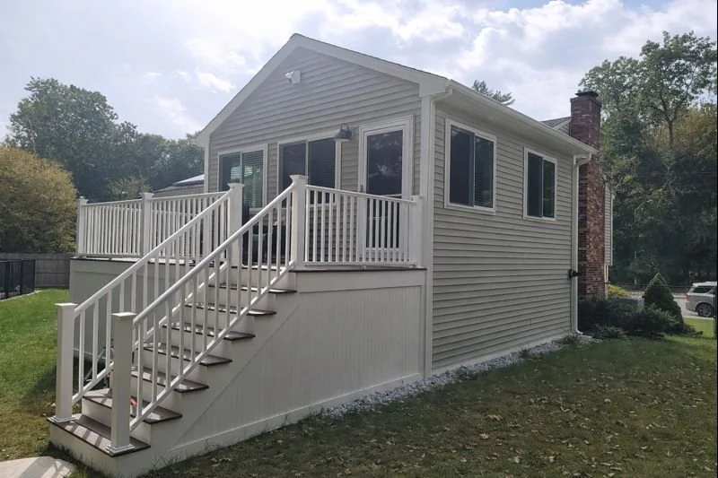 Family room addition with elevated deck and stair access, exterior view, New England home remodel