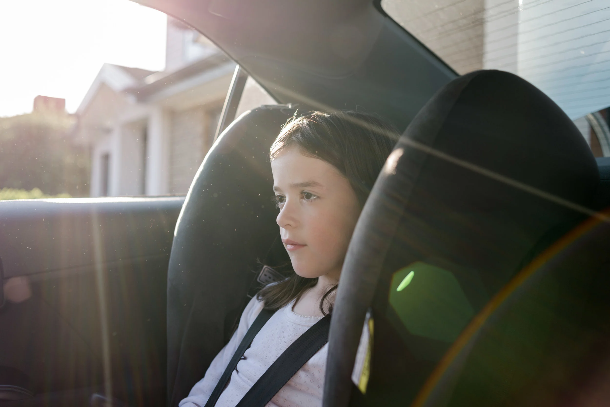 Young girl sitting in the car with sunflare-03072.JPG