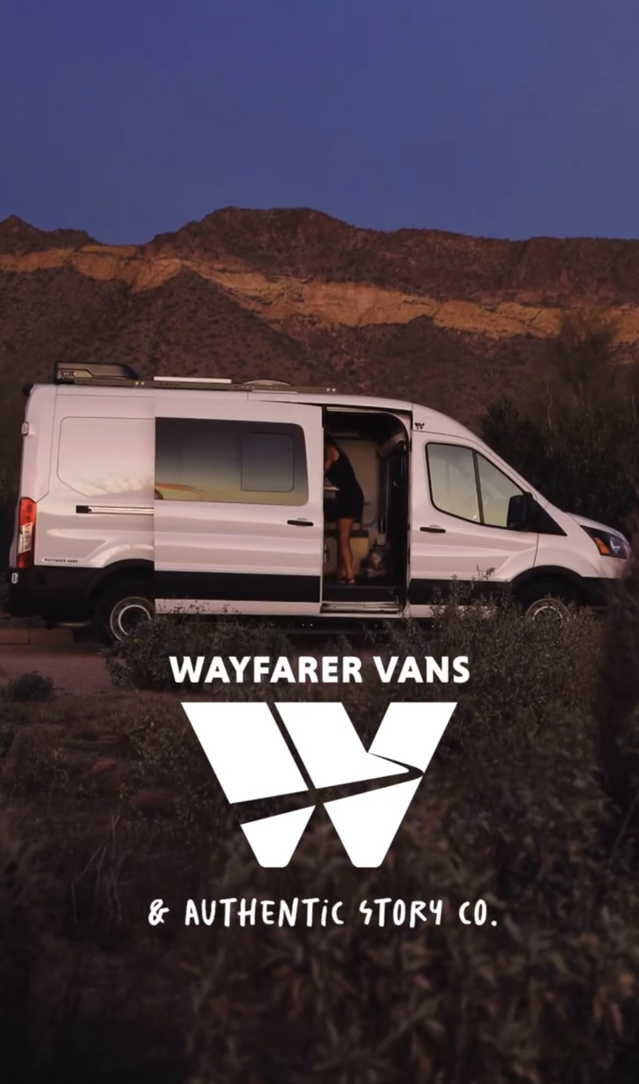 Wayfarer Vans is written on the photo and beneath it is a big white 'W', their logo. Underneath it says Authentic Story Co. There is a white van with the door partially open behind that. The sky is dark blue and it's dusk out. There are mountains.