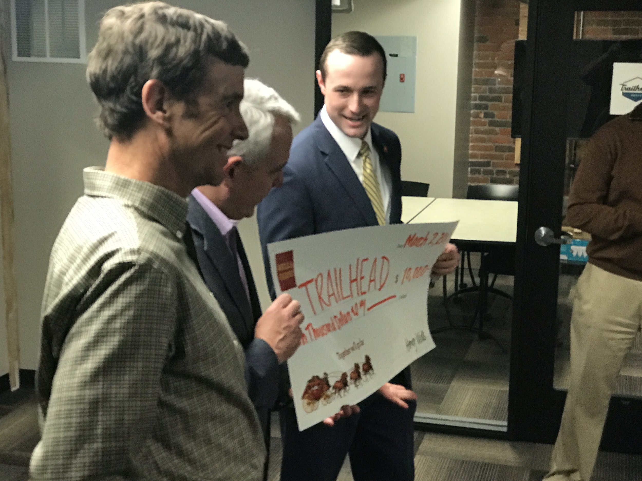 Trailhead's Raino Zoller grins as Boise Mayor Dave Bieter recieves a check from Wells Fargo's Flip Kleffner
