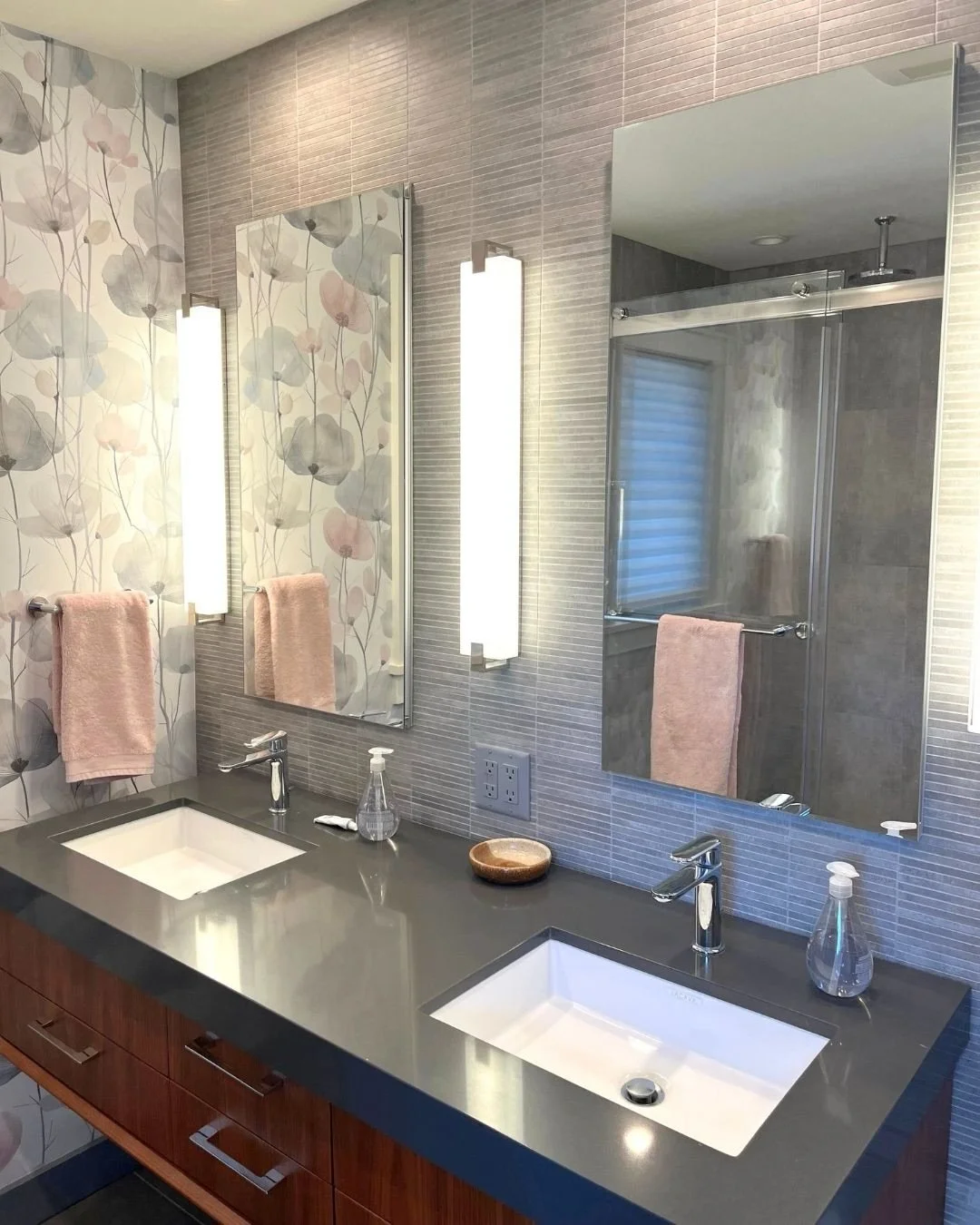 April showers bring May flowers. 🌸 Our client wanted to add personality and color to their Primary Bathroom.  We chose this poppy wallpaper in shades of peach and soft gray to complement the existing walnut vanity and tiles.  The result is a space t