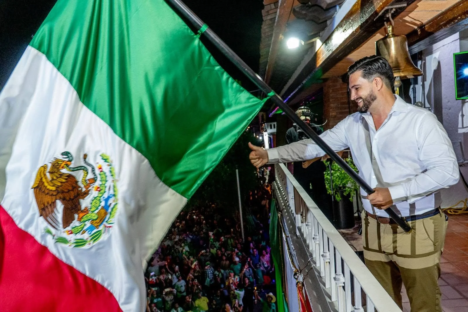 Mayor Luis Ernesto Munguía González stepped onto the main balcony of the Palacio Municipal, received the Mexican flag