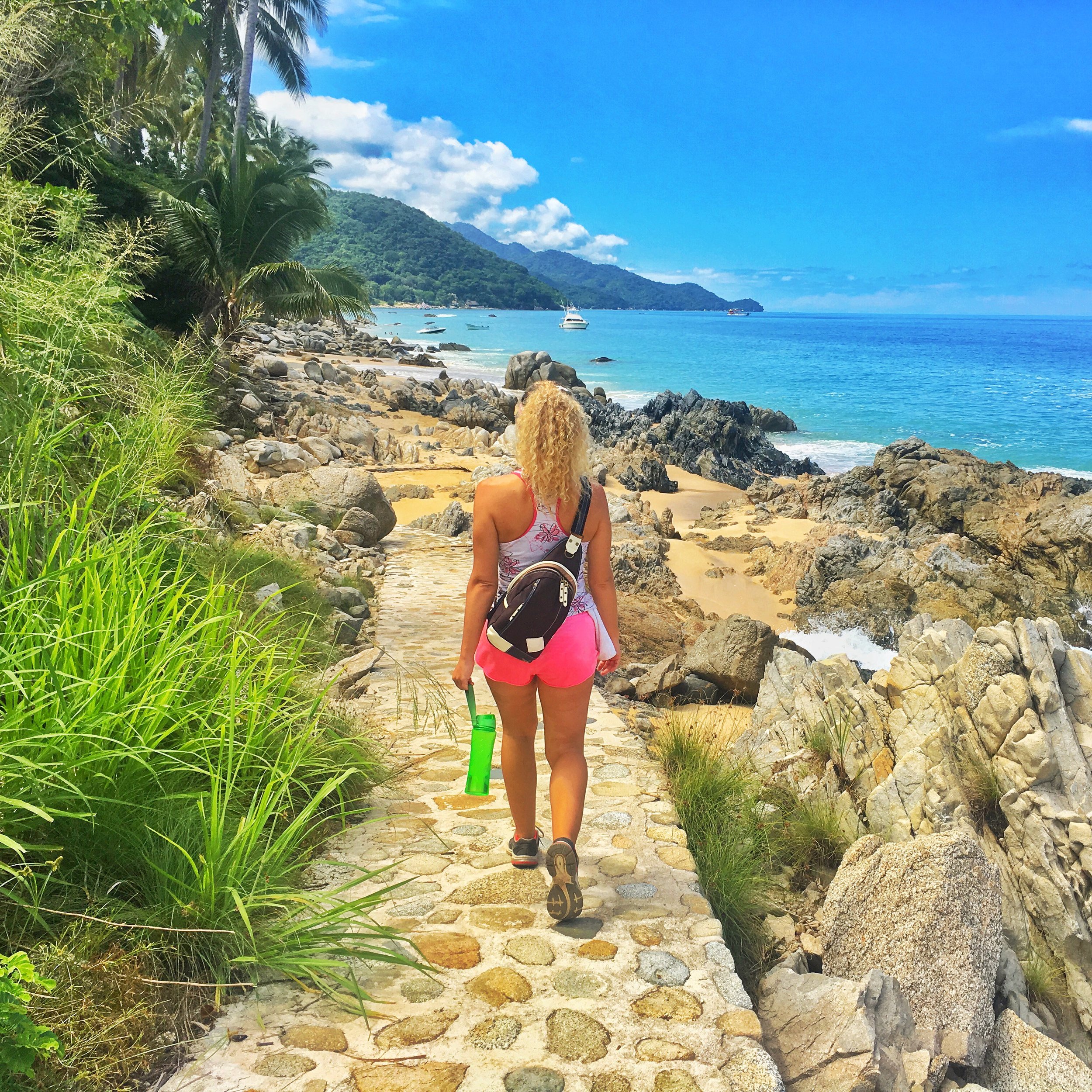 Guest walking coastal jungle trail down to hidden beach on My Deztination hike..