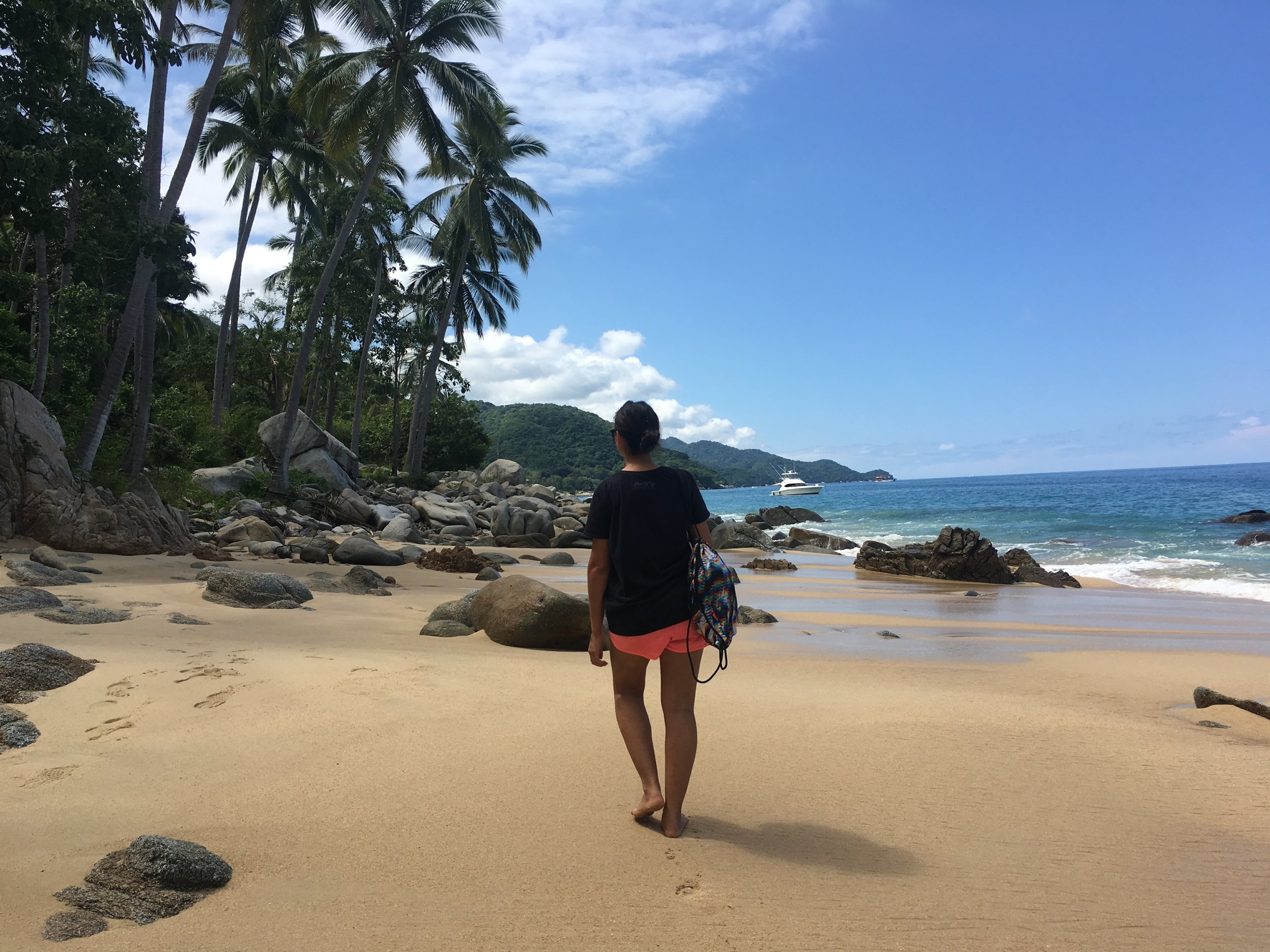 Guest walking barefoot on sandy beach trail toward Las Ánimas.