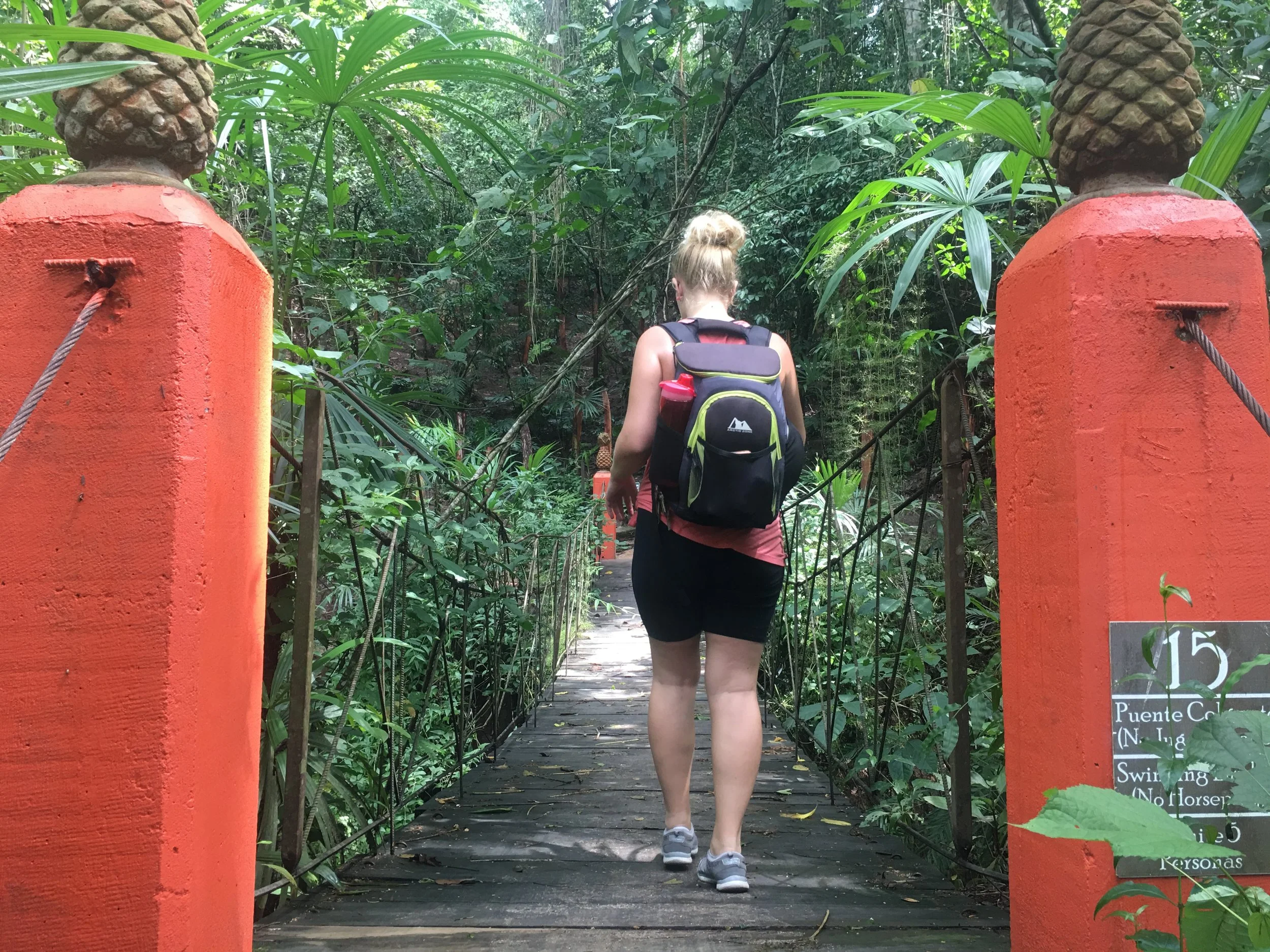 Guest crossing small suspension bridge on My Deztination botanical tour.