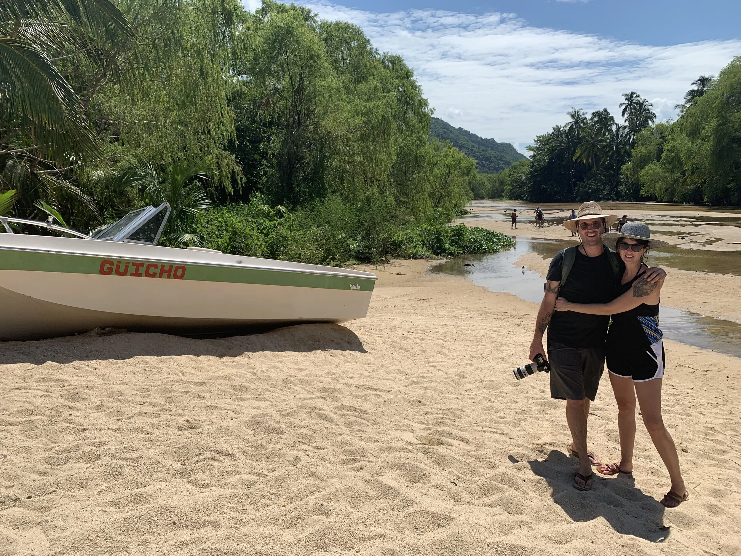 Couple standing by boat on Yelapa Beach with My Deztination.