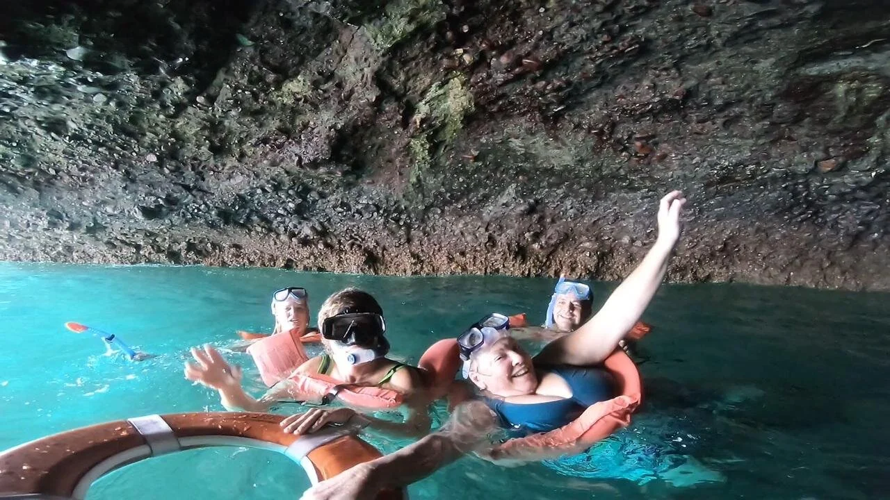Women smiling inside Los Arcos arch with buoyancy aids on My Deztination tour.