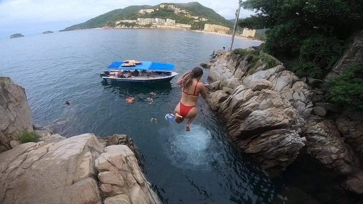 Guest jumping off high rock into water at Mismaloya with My Deztination.