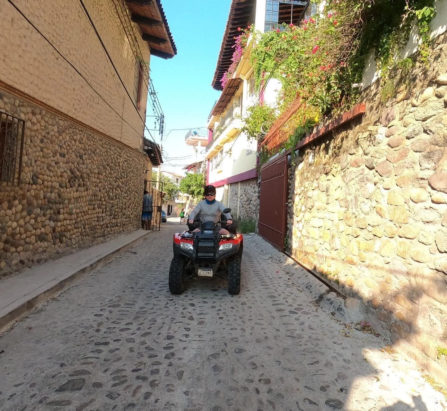 Guest riding ATV down cobblestone street with My Deztination.