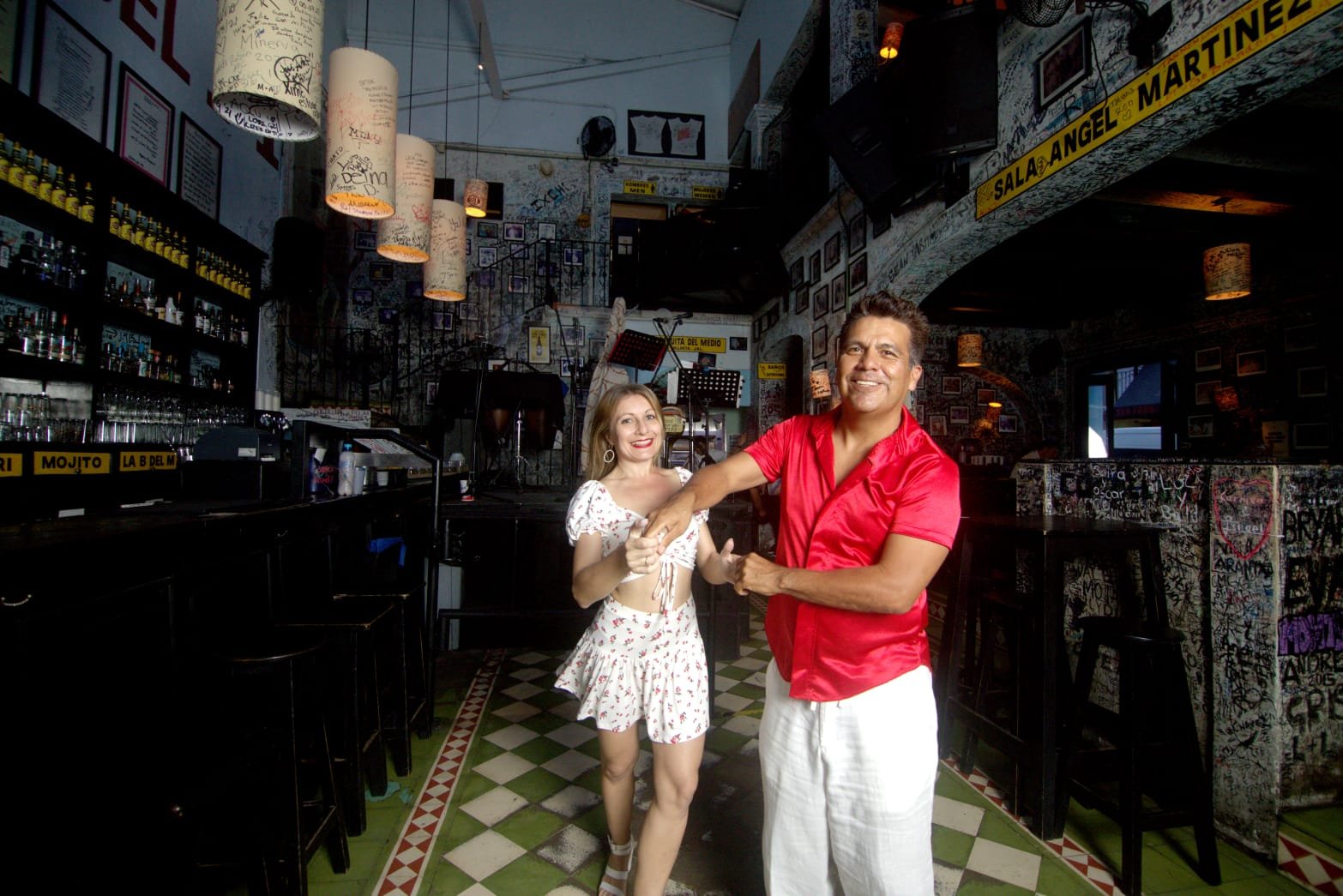 Salsa teacher guiding student on dance floor inside La Bodeguita with My Deztination.