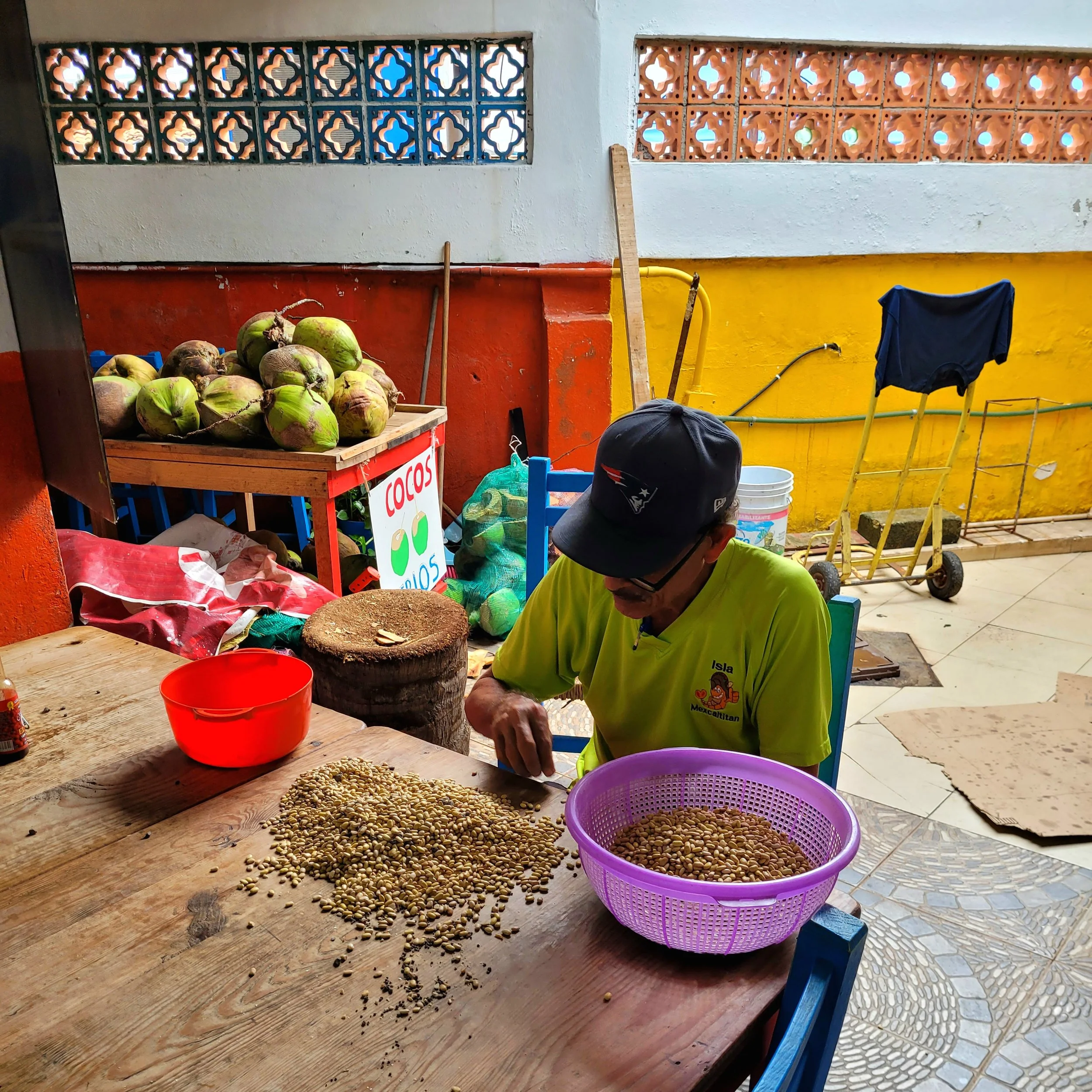 Local vendor sieving beans at table during My Deztination food tour.