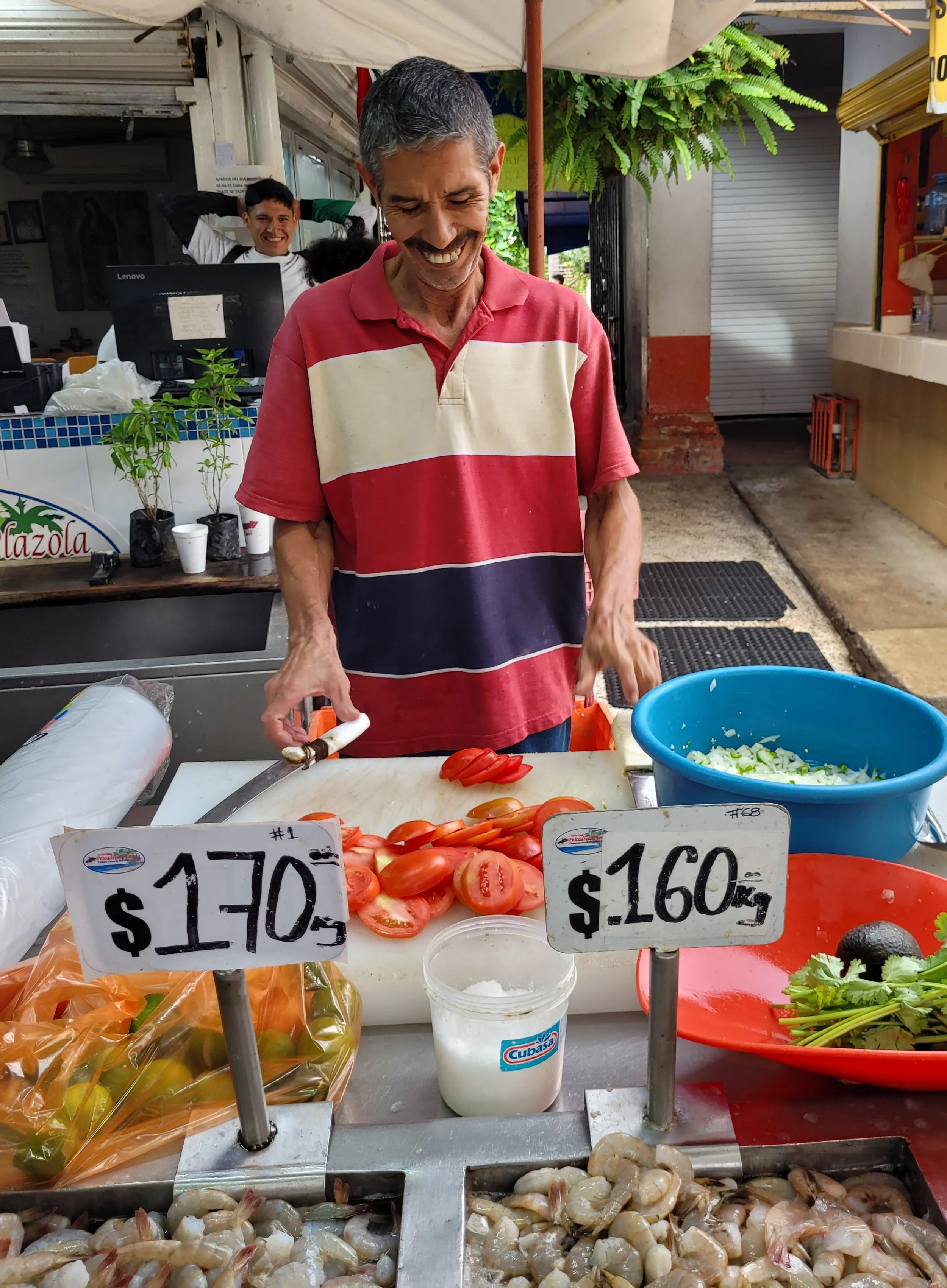 Local man chopping tomatoes and smiling on My Deztination market visit.